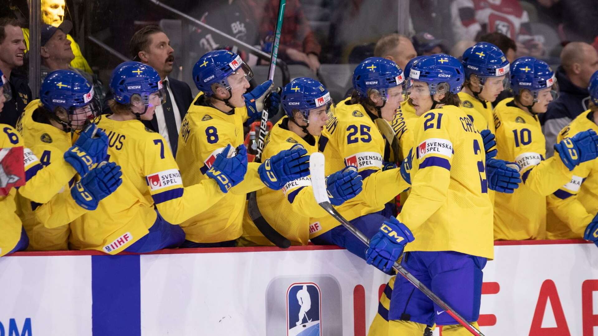 Leo Carlsson firar med lagkamraterna efter att han gjort Sveriges första mål i segermatchen mot Finland. Han satte ett till. Sverige är därmed klart för semifinal i JVM.
