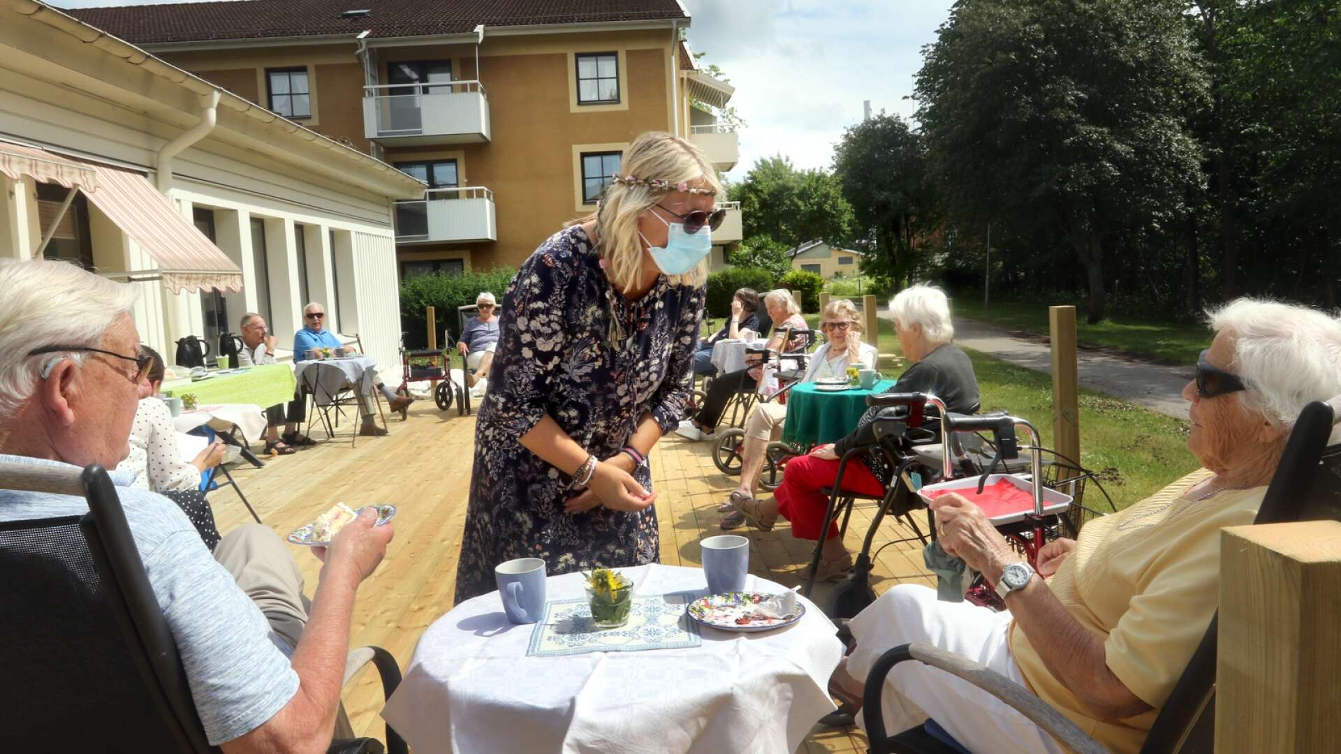 På baksidan av seniorboendet Humlet, på den nybyggda altanen, bjuder Annelie Blomberg de äldre på tårta och kaffe.