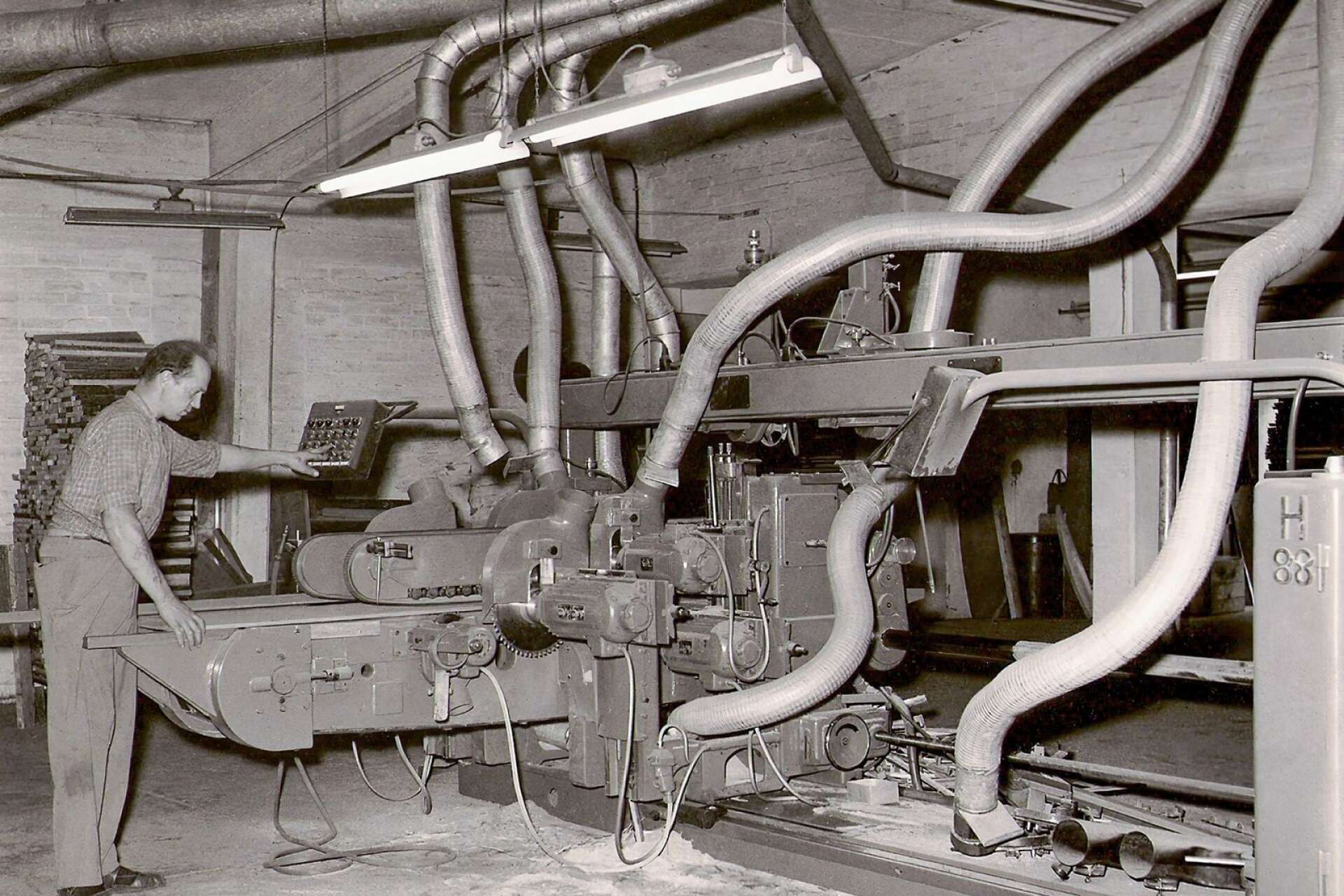 Arne Stjärnefeldt arbetar vid en dubbel tappmaskin i Albert Larssons möbelfabrik 1956.