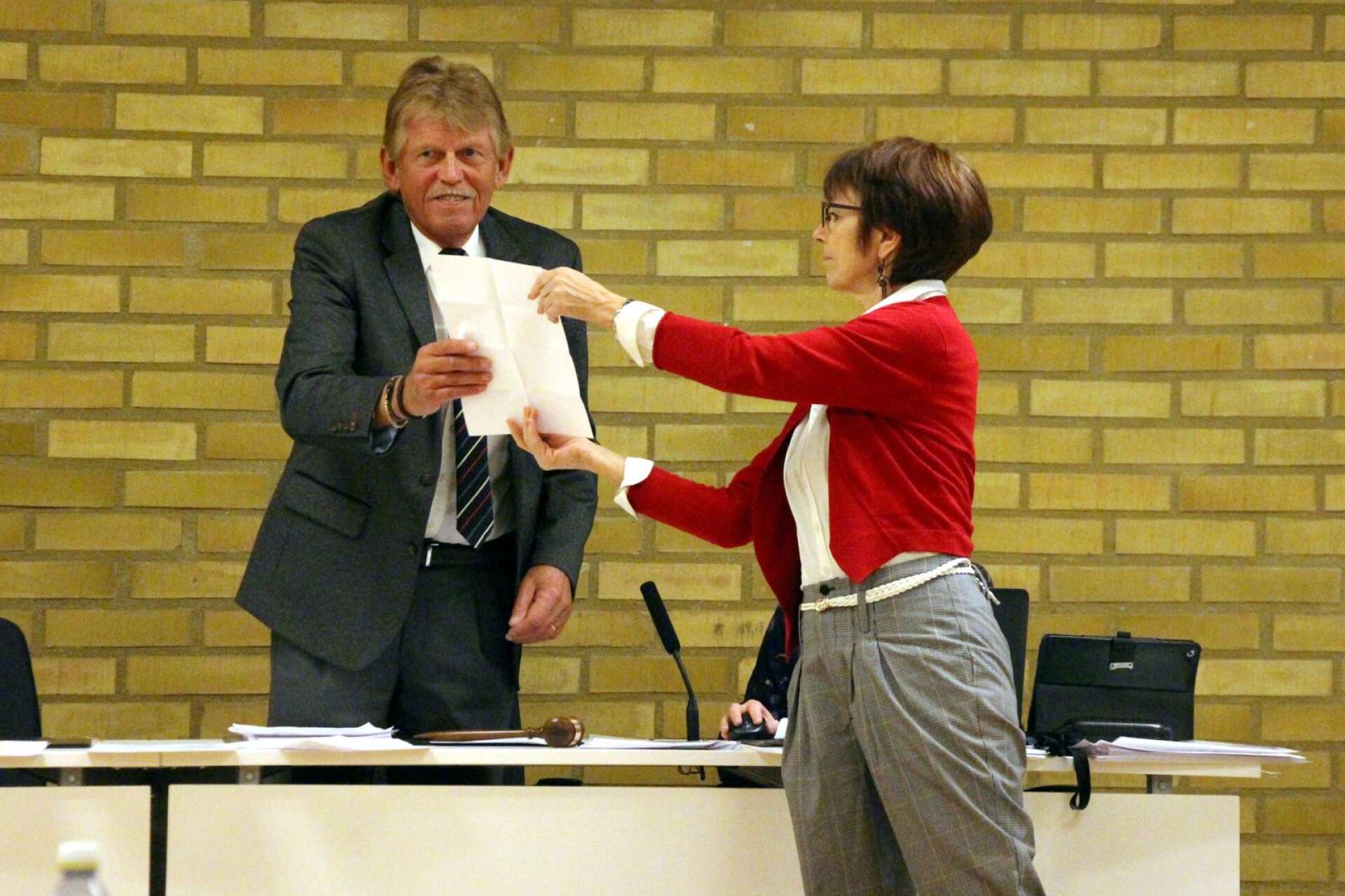 Hans-Göran Larsson (RV) får ett dokument av kommunchef Elisabet Olsson på vilket det framkommer vem som blir fullmäktges nya ordförande.