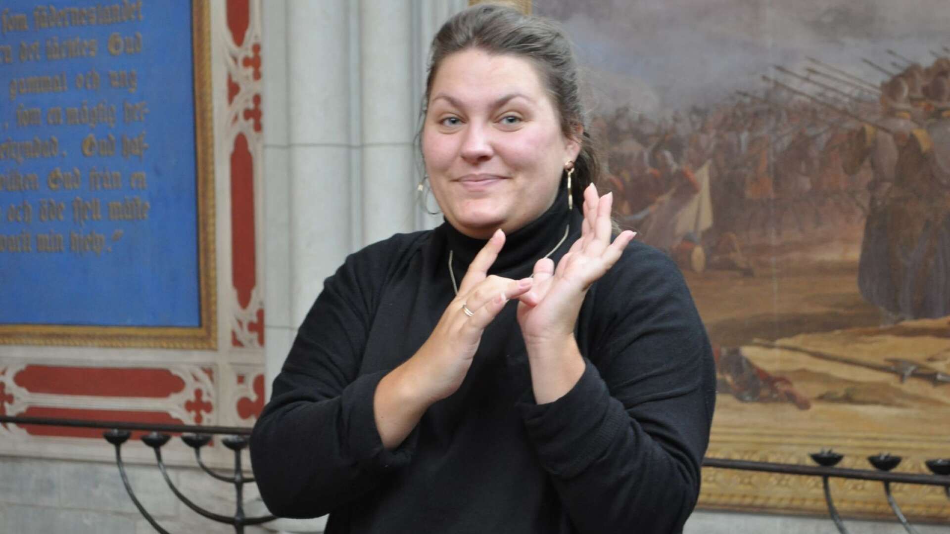 Emmy Lindgren håller i ett event vid temadagarna Livet värt att leva. Ämnet är teckenspråk. Tecknet på bilden står för &quot;Jesus&quot;.