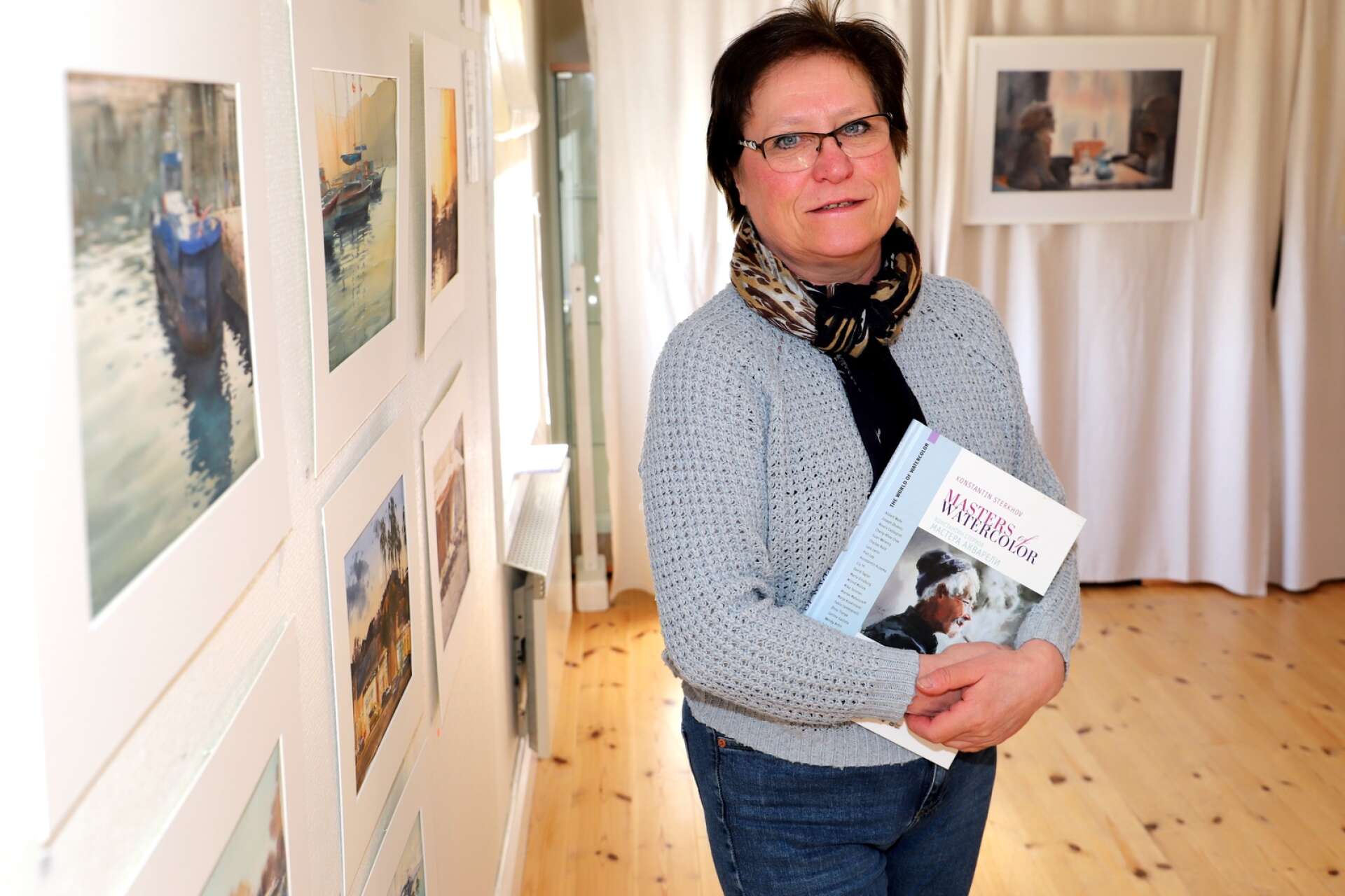 Olga Karlsson med en av Konstantin Sterkhofs böcker om konst. Hon är akvarellkonstnär och håller liksom Sterkhof ofta i målerikurser.
