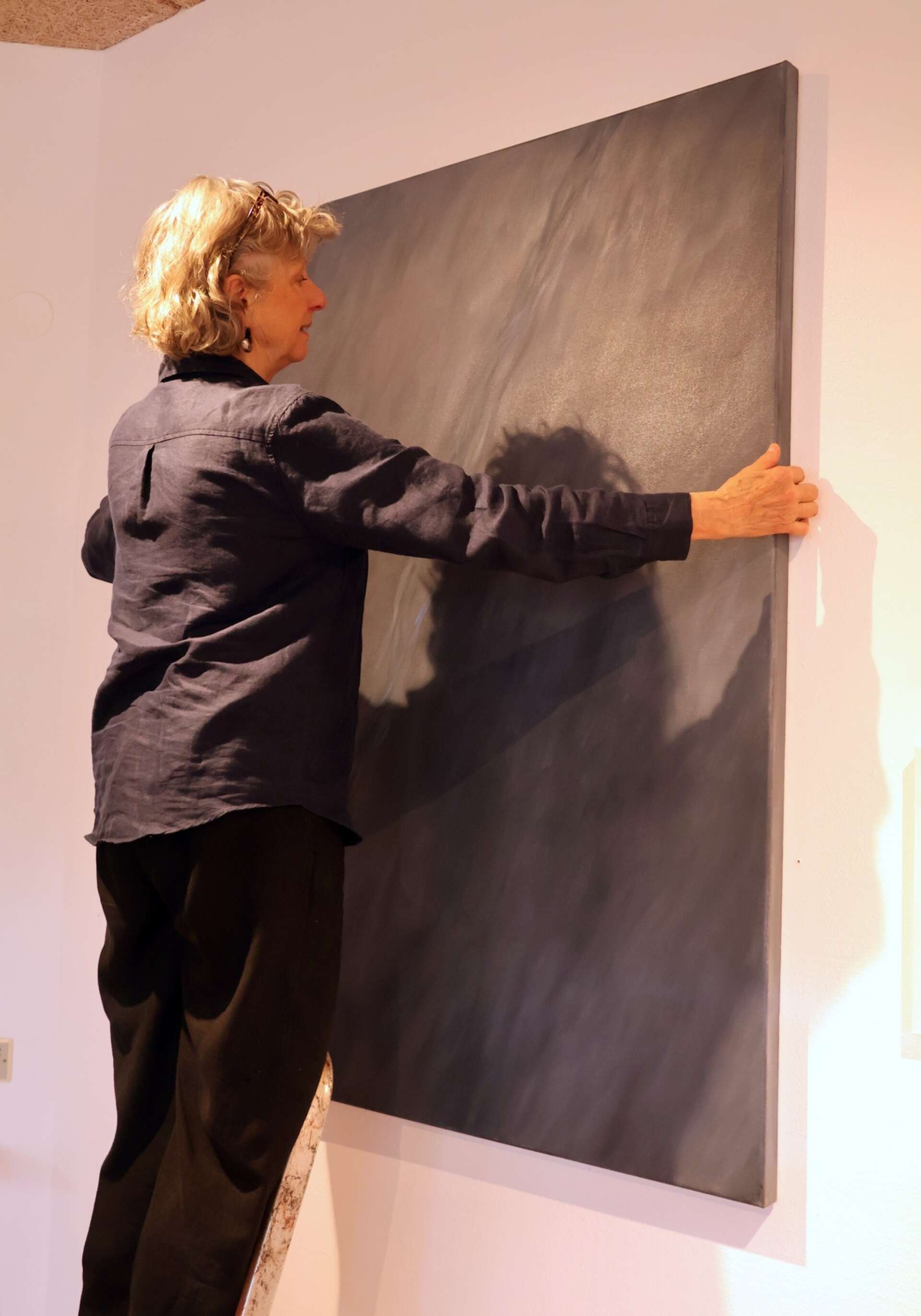 Elisabeth Wennberg i arbete med hängningen av en av sina stora oljemålningar.