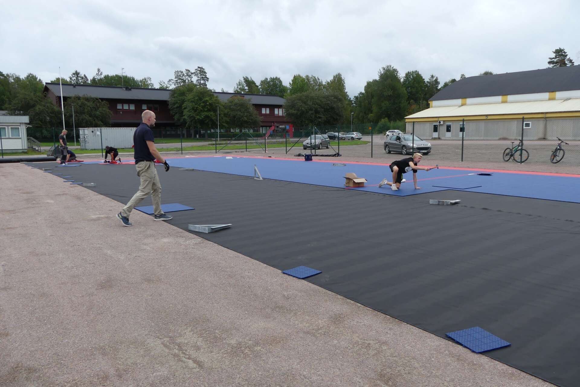 Fredrik Reuter, sektionsansvarig för innebandyn i Säffle SK, finns på plats och hjälper till med att lägga mattan.