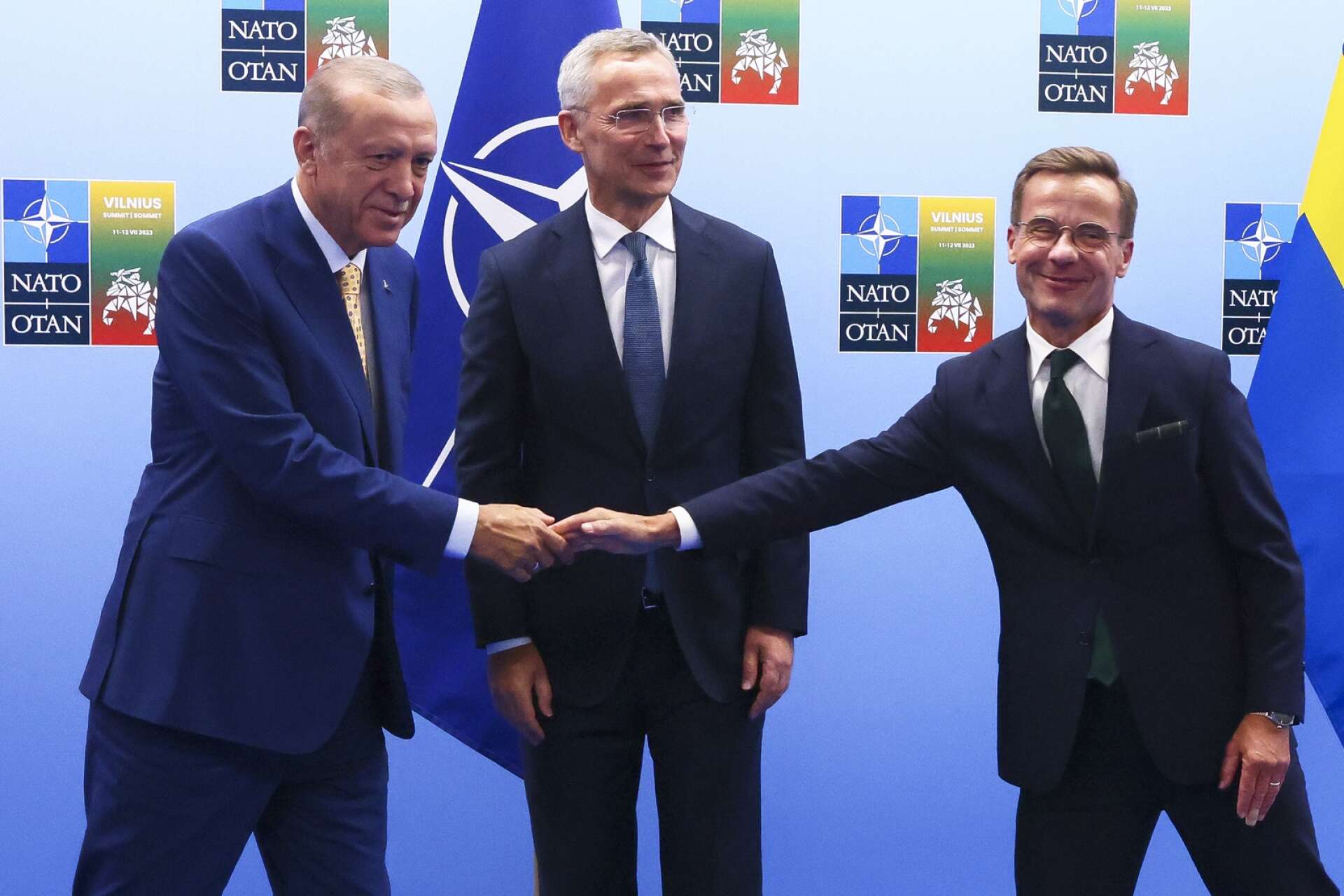 Turkiets president Recep Tayyip Erdoğan skakar hand med statsminister Ulf Kristersson (M) vid Natos toppmöte. I mitten Natos generalsekreterare Jens Stoltenberg.