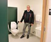 Magnus Dalsbo visar att toalettstolar och handfat sitter på aningen lägre höjd.