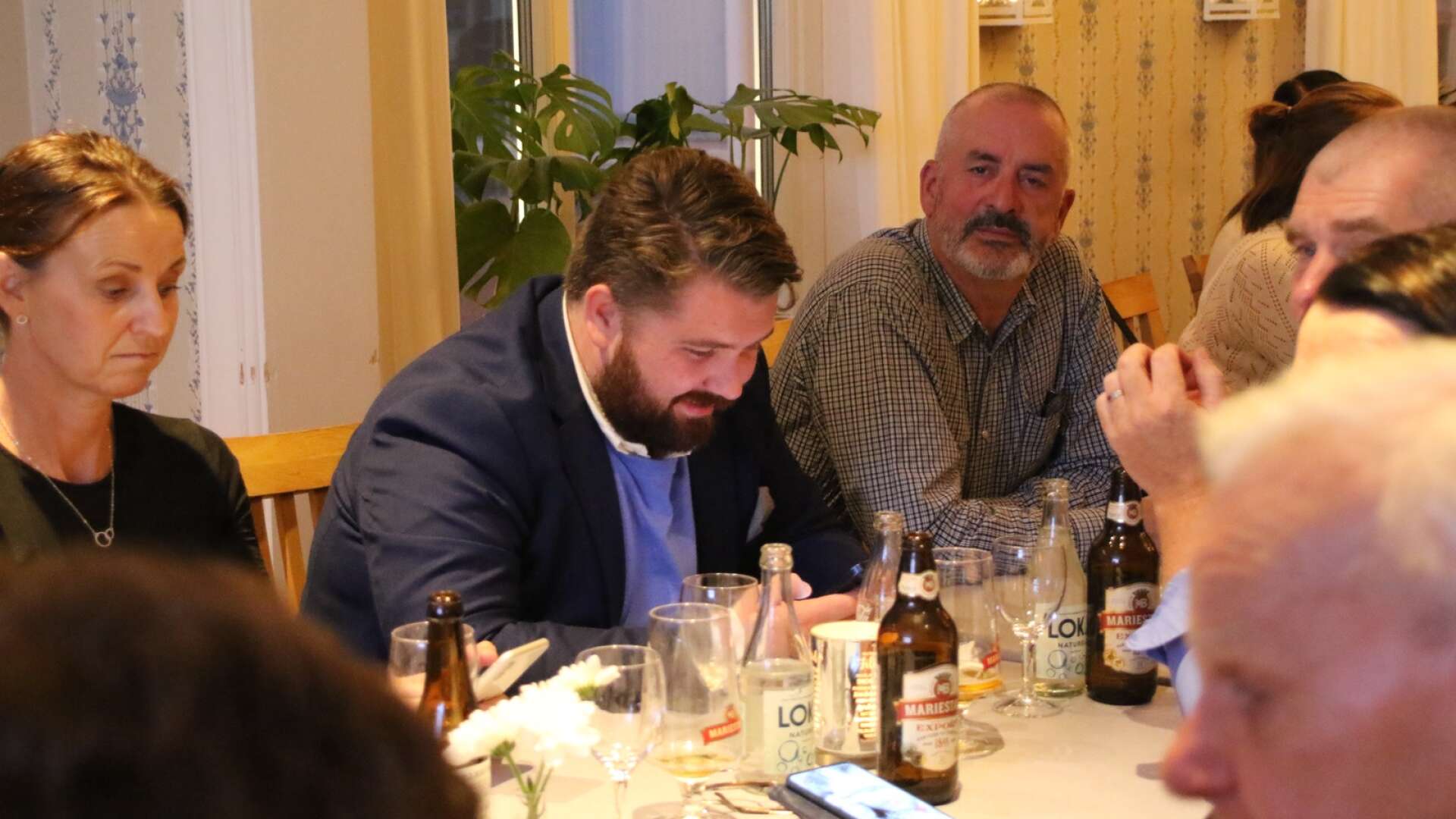 Filip Dahlöv (M) (i mitten) följde valnattens utveckling i sin mobil. Nu är hans parti en del av den nya majoriteten i Filipstads kommun.