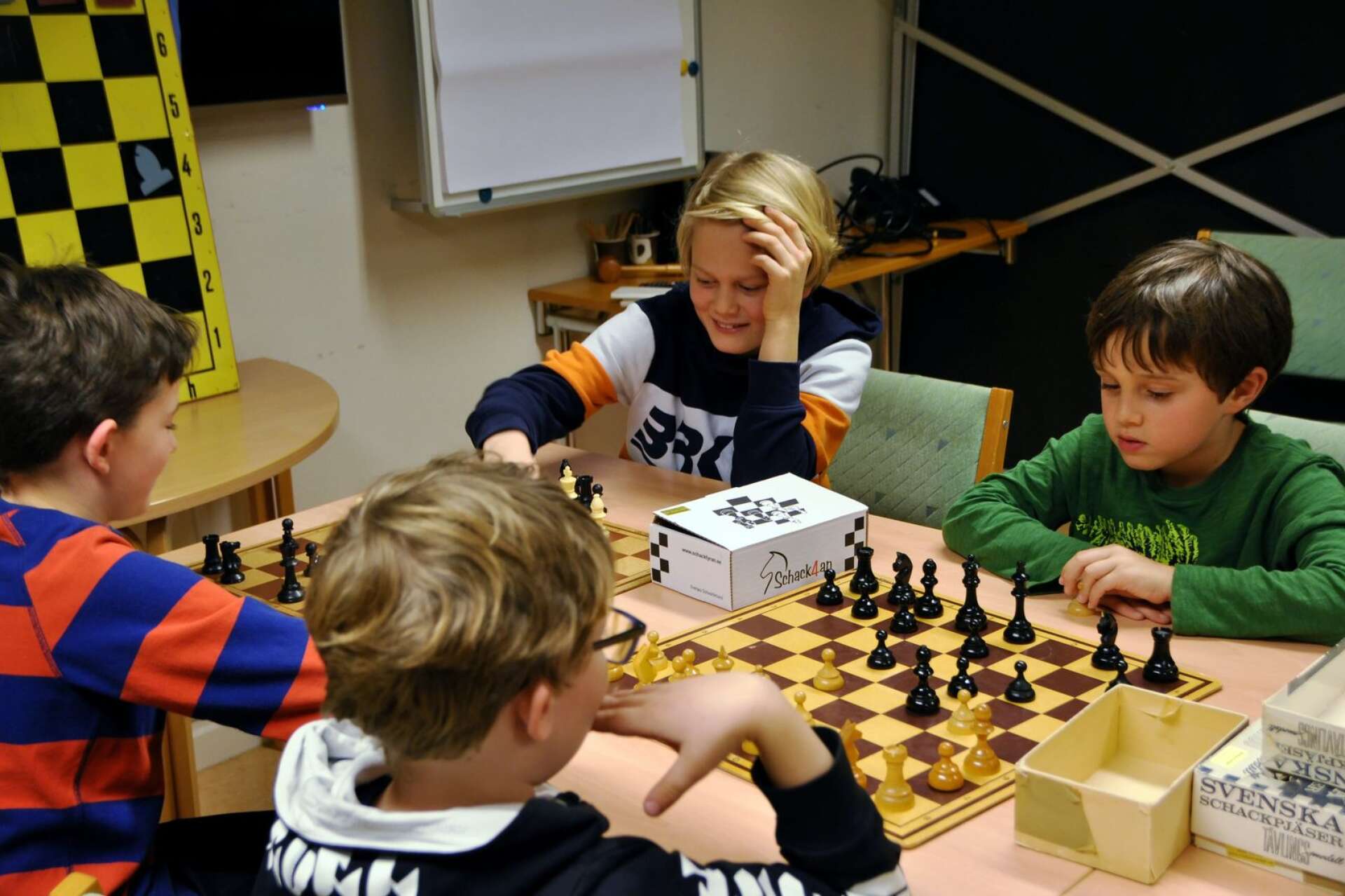 Unga spelare vid schackbordet i full tankeverksamhet inför nästa drag.