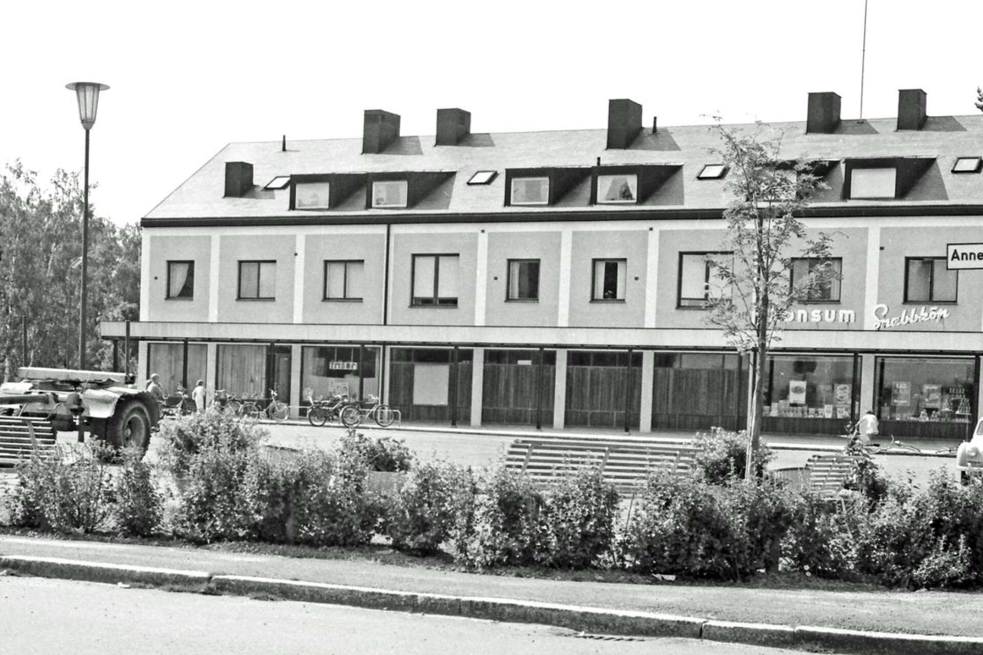 Annelundstorget 1958. Huset till höger stod färdigt 1952. Då öppnade Rudolf Karlsson herrfrisering där. Konsum flyttade dit i mitten av 1950-talet. Lastbilen tillhörde Billerud. Det avslöjas av Billerudsörnen på dörren. Och visst fanns det blommor och soffor. 