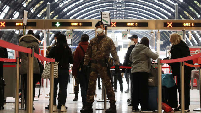 Poliser och soldater kontrollerar passagerare vid tågstationen i Milano.