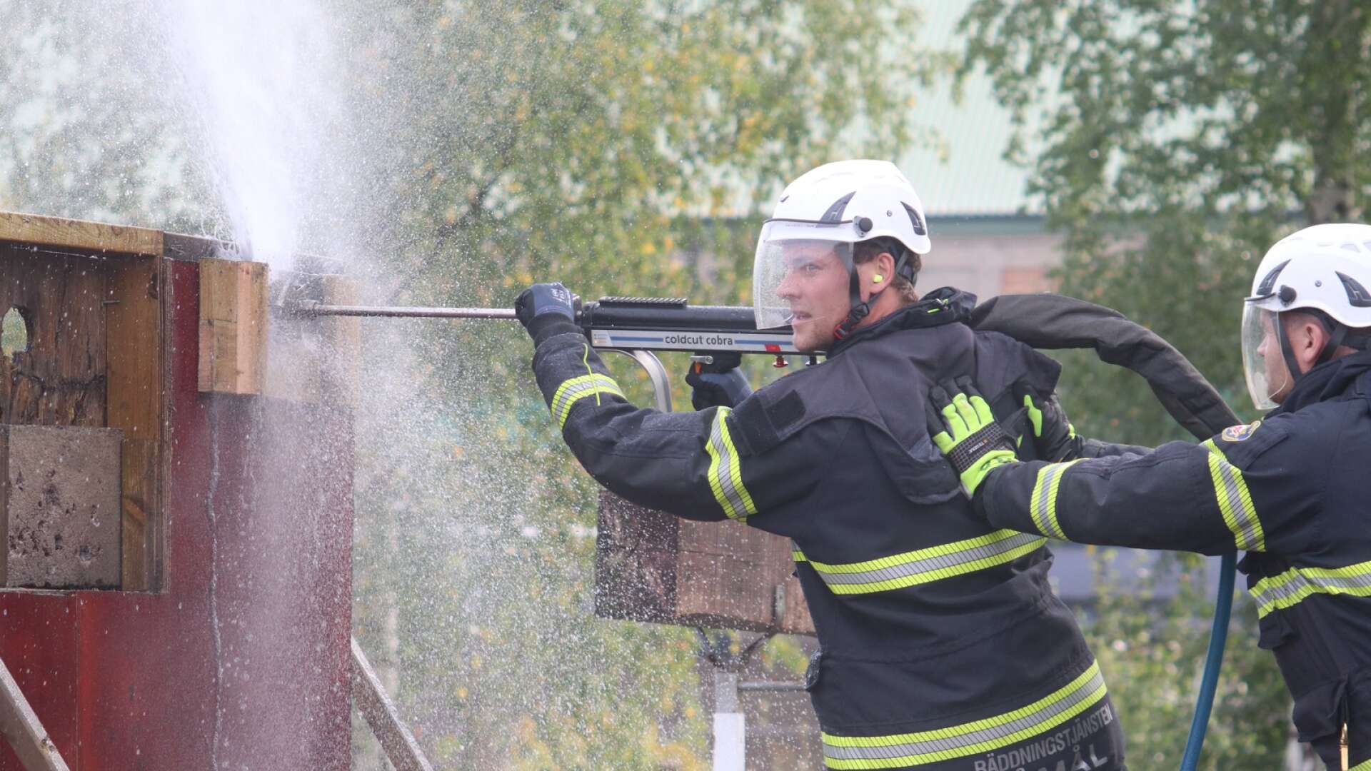 Brandmännen Daniel Karlsson och Anders Karlsson demonstrerar räddningstjänstens nya skärsläckare.
