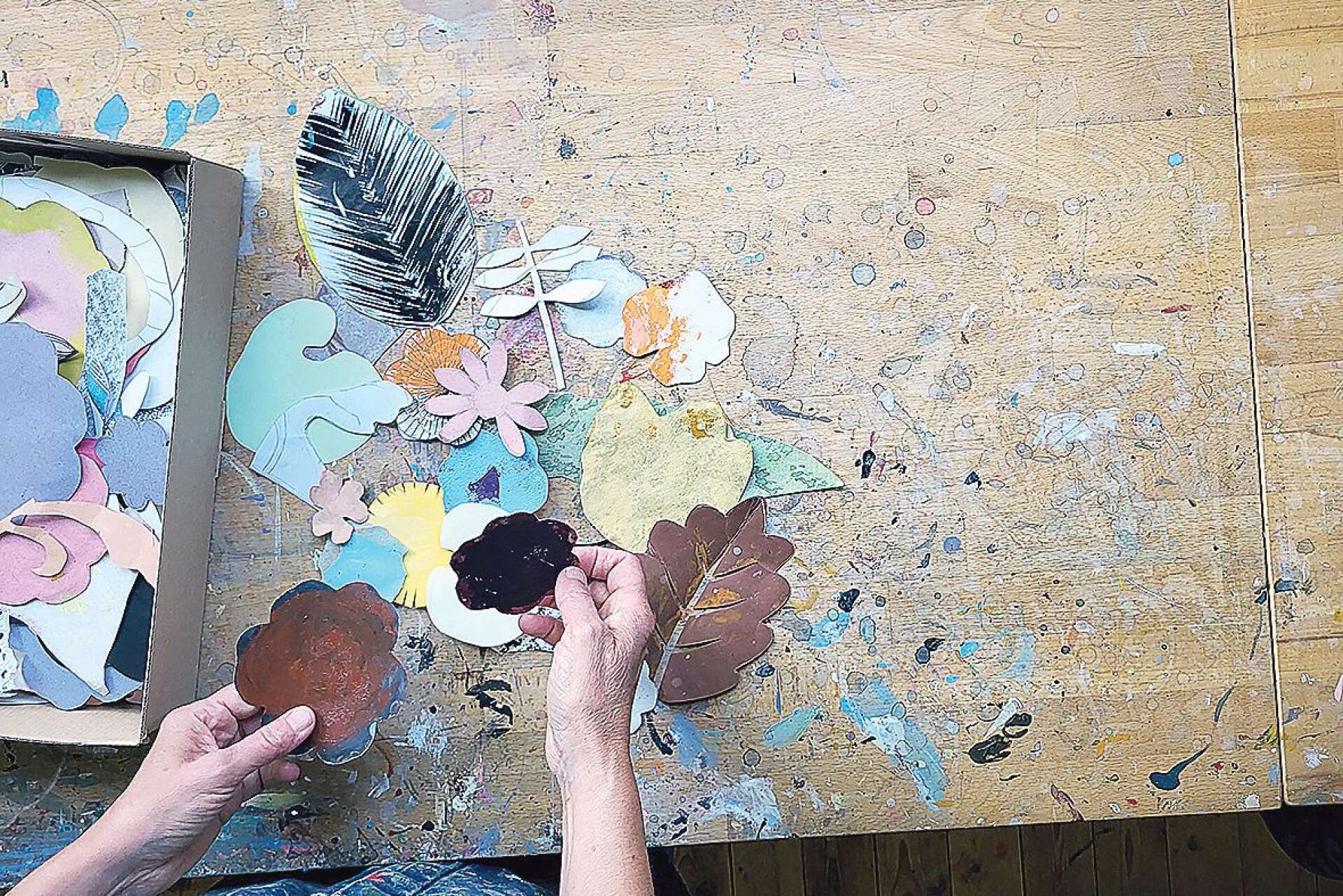 INSPIRATIONSBANK. I en liten papplåda förvarar Birgitta Fjaestad utklippta former i olika färger och strukturer. Med hjälp av formerna kan hon leka sig fram till en färdig bild, redan innan färgen når duken.