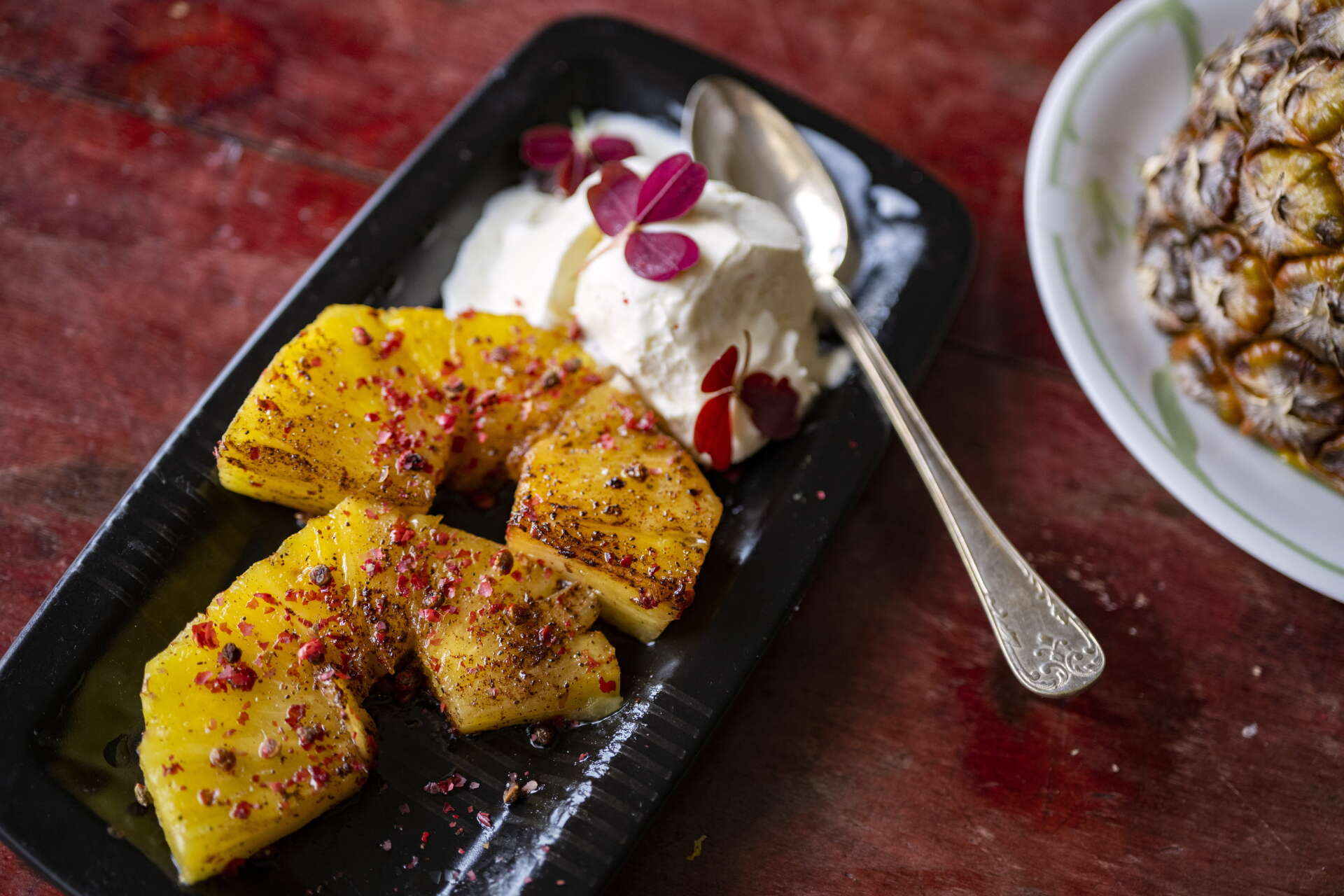 Varför inte våga sig på att ha rosépeppar i en dessert? Här med kanelstekt ananas och vaniljglass.