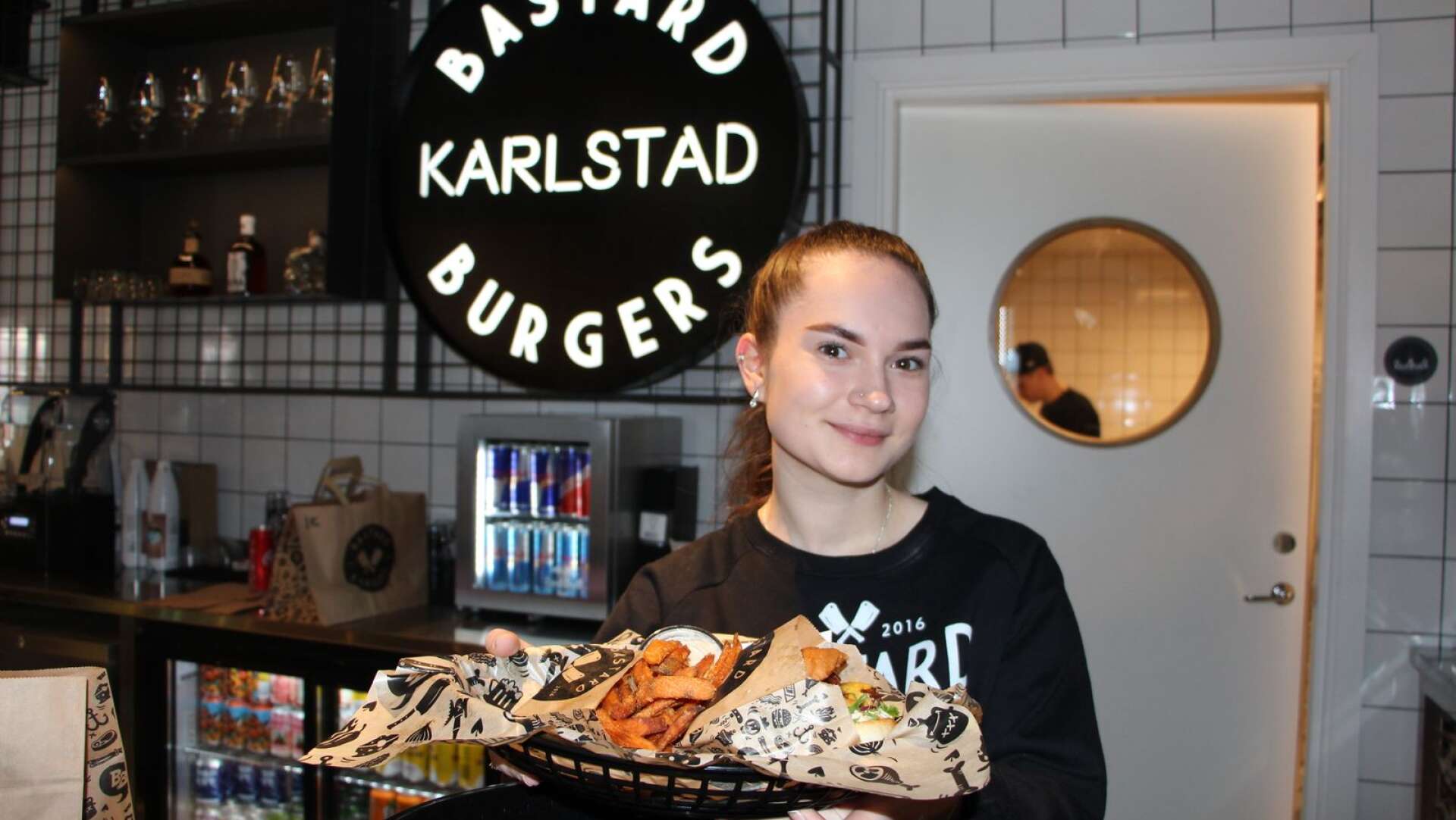 Anna Kiseleva på nyöppnade Bastards Burgers i Inre hamn visar upp en hamburgermeny.