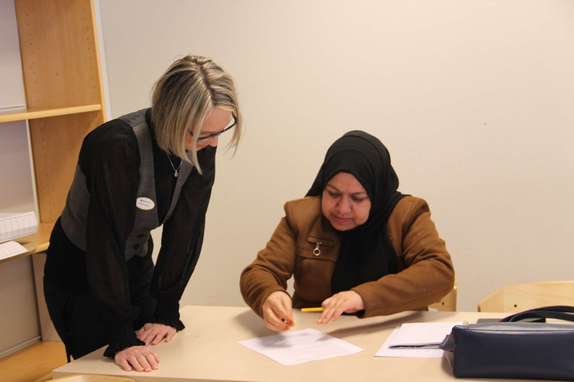 Läraren Benita Antman hjälper Bibi Fraiba med en uppgift vid en lektion i svenska på Lärcenter.