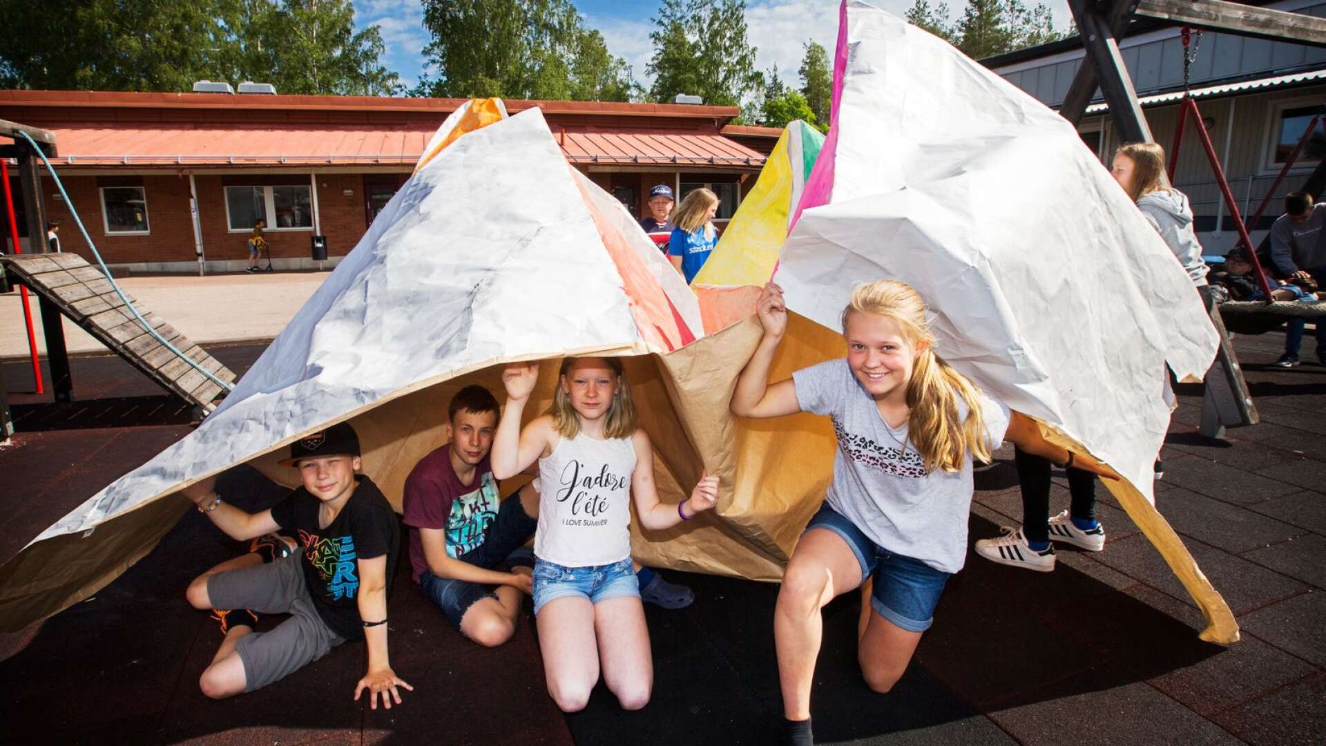Elever på Jättestenskolan har gjort en jätteloppa av 8 x 8 meter papper från den nya kartongfabriken på Gruvöns bruk. Nelly Norlén syns längst fram till höger.