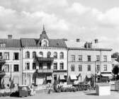 Norr om torget fanns den gamla bebyggelsen kvar när Säffle blev stad. Snart skulle hus i rött tegel ersätta. Till höger skymtar Viktorinska huset och till höger om Perssons gränd det hus som idag bland annat inrymmer tandklinik. 