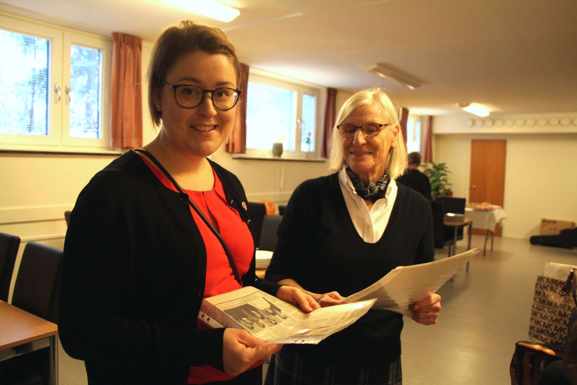 Ida Ekeroth Clausson och Margareta Olin tittar på gamla tidningsurklipp från S-kvinnor Mariestads hundra år som gått. På jubileumsfirandet gick det att ta del av historien, samtidigt som klubben blickade framåt.
