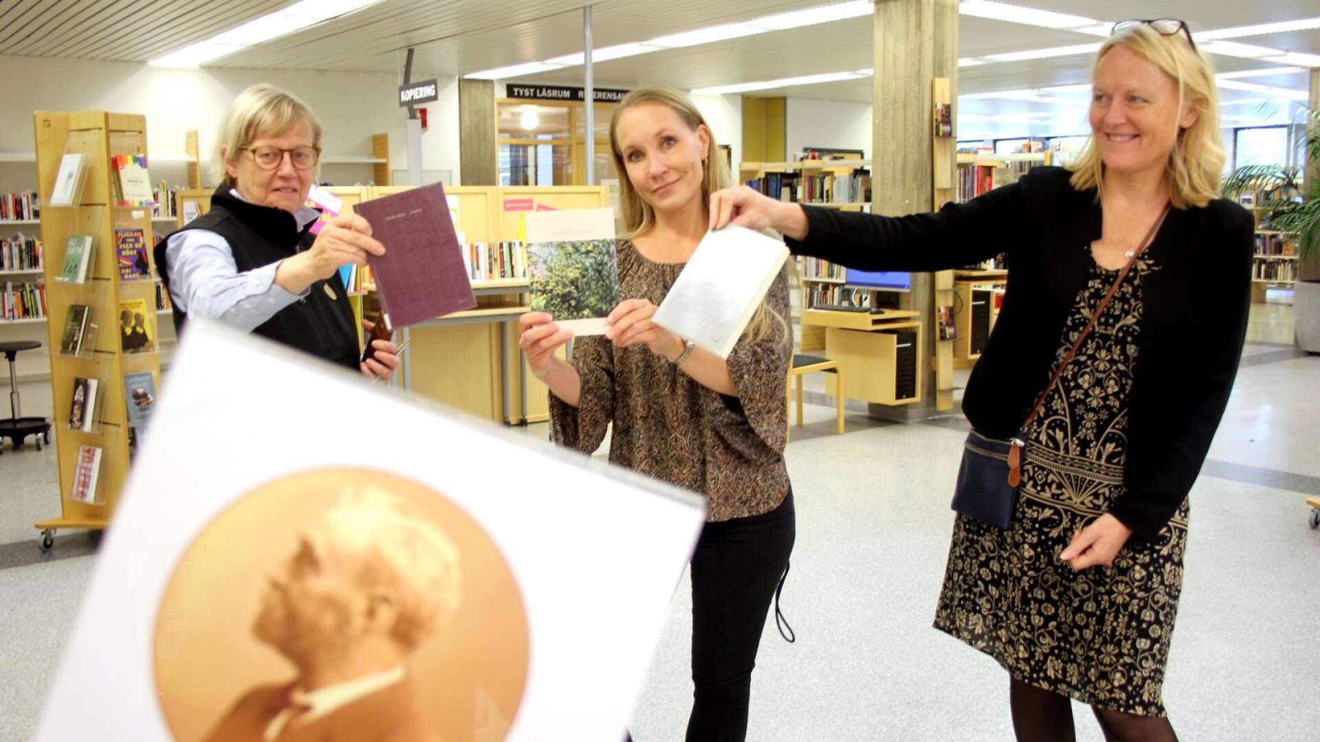 Annika Holmberg, Sara Andersson och Åsa Hansen på Stadsbiblioteket i Karlstad med de tre exemplar av Louise Glück-böcker som biblioteket fick fram direkt efter beskedet.
