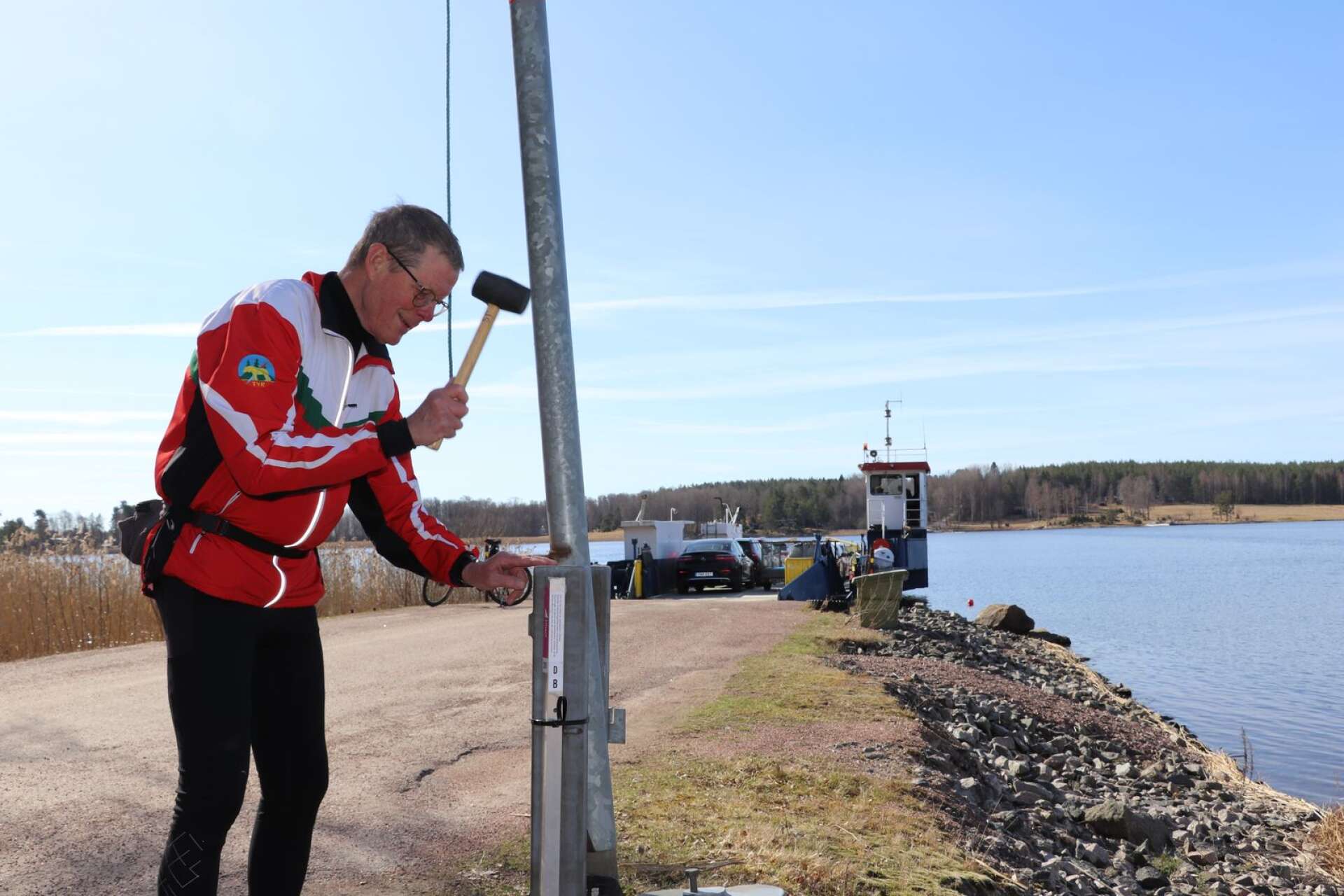 Jan Svensson sätter upp en av stolparna som hör till det vattennära kartområdet vid Jäverön.