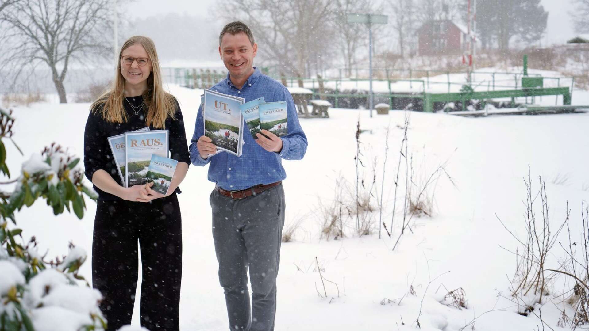 Julia Kvarnlöv, marknads- och försäljningschef på Visit Dalsland, och Johan Trollnäs, vd för Visit Dalsland och Dalslands kanal ses i ett snöskrudat Håverud för bara några dagar sedan med 2021 års upplaga av Dalslandsmagasinet UT.