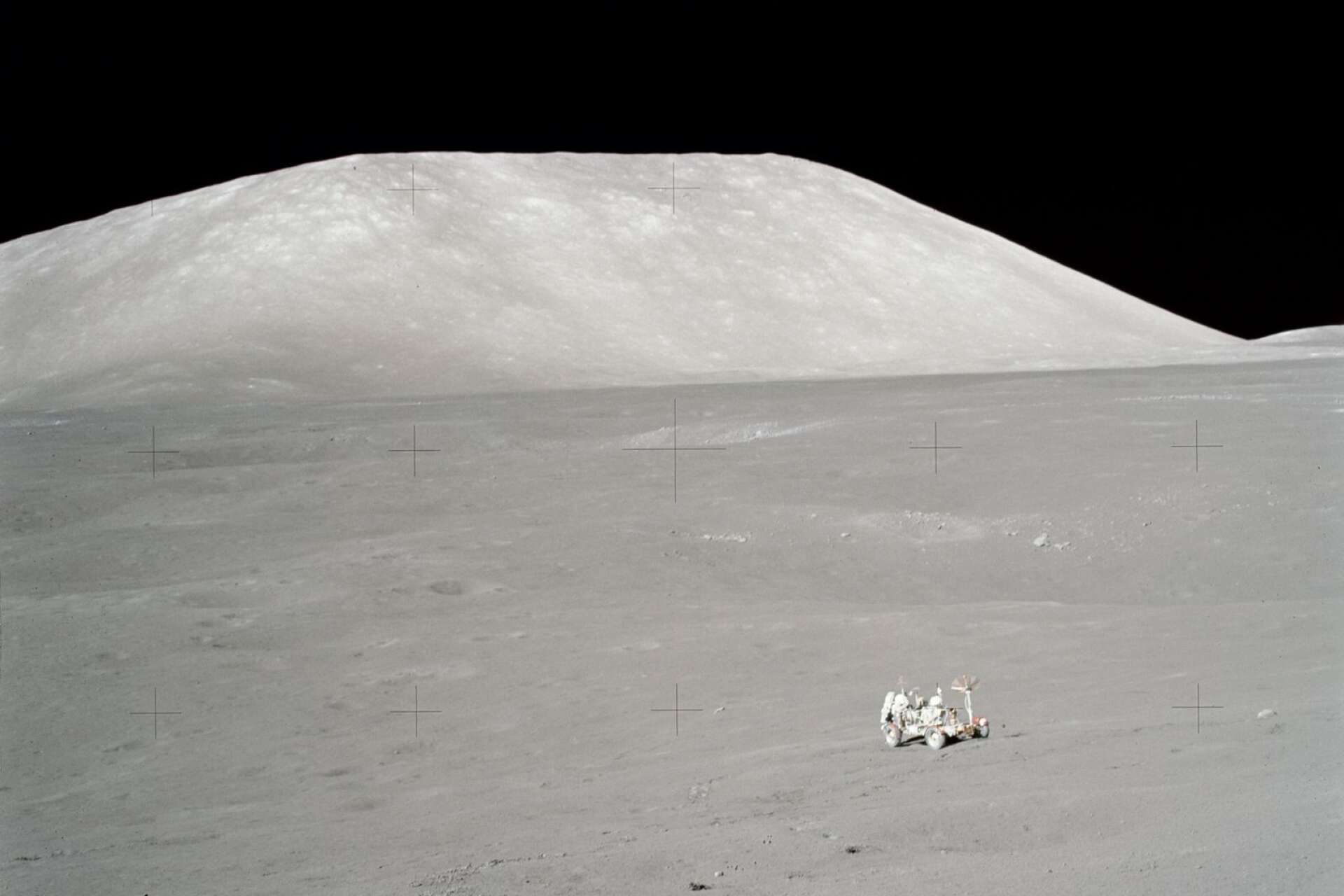 Schmitt vid månbilen med bergmassiv i bakgrunden.