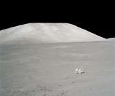 Schmitt vid månbilen med bergmassiv i bakgrunden.