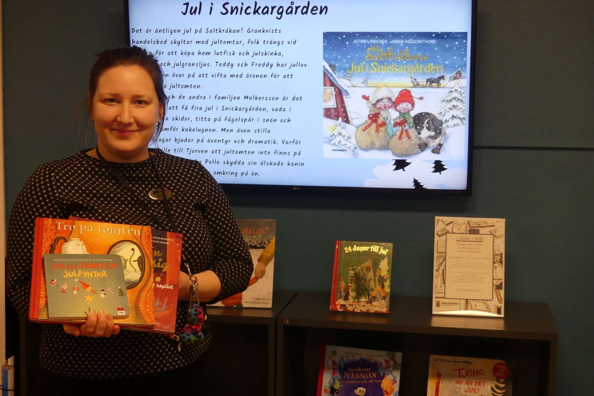 Kerstin Helenesdotter som jobbar på barn- och ungdomsavdelningen på Säffle bibliotek visar upp en del barnböcker med jultema. Det finns många att välja på.