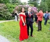 Rafaella Al Homsi i röd långklänning i sällskap med Karl Bergvall med matchande röd ros på kavajslaget.