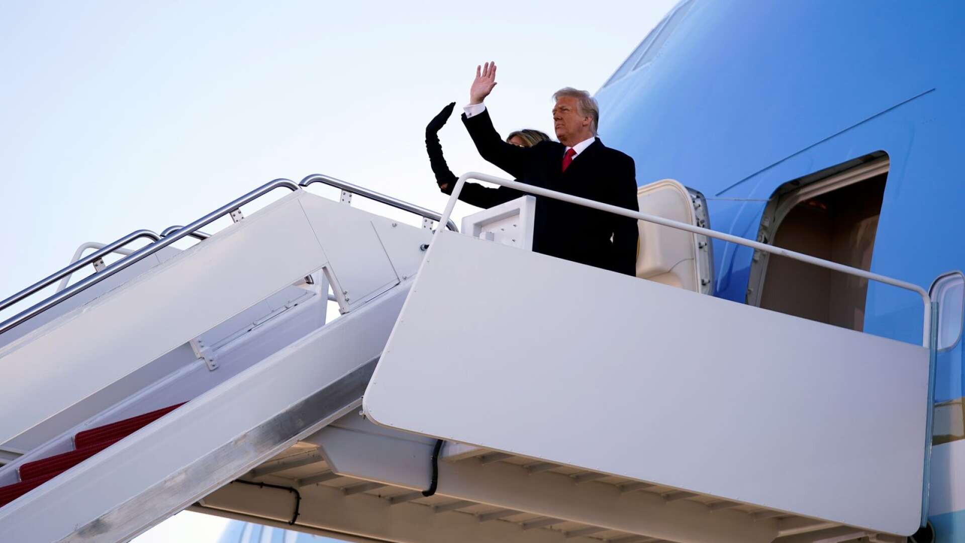 Donald och Melania Trump vinkar farväl inför sin sista resa med Air Force One.