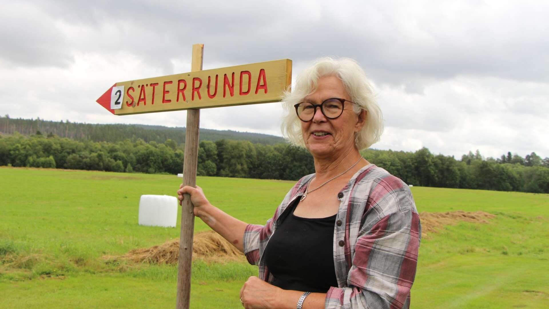 Säterrundan blev inställd i år, men Ingela Kåreskog plockar fram en av skyltarna som visar riktningen för evenemanget.