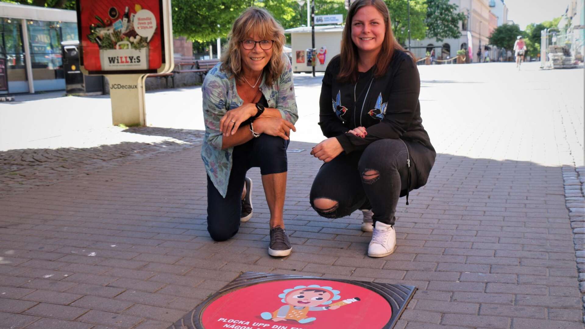 Karlstads kommuns avfallsrådgivare Karin Vogt och gatuingenjör Emma Lindström vid ett av totalt 30 märken som hoppas inspirera rökare att fimpa rätt.