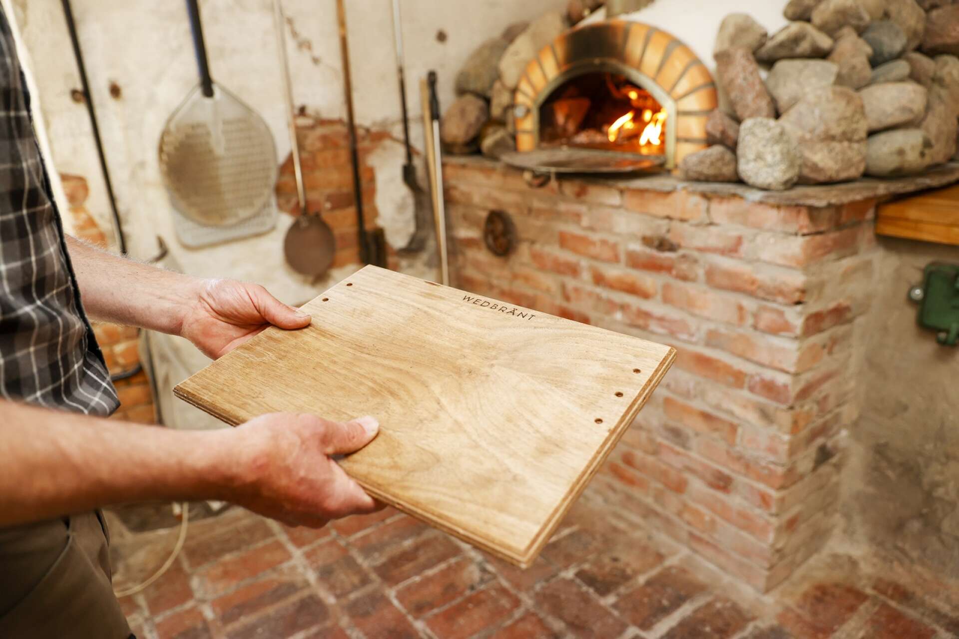Återbruk är ett nyckelord i Wiksfors bruk. En gammal hylla har blivit material till de träskivor som pizzorna serveras på. 