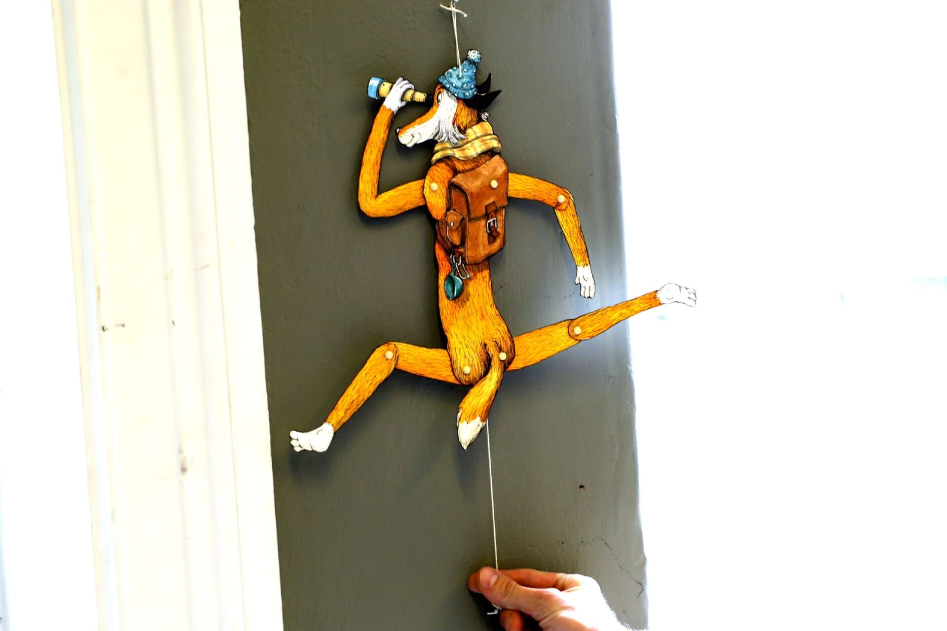 En sprattelgubbe lockar till ett ryck på galleriväggen.