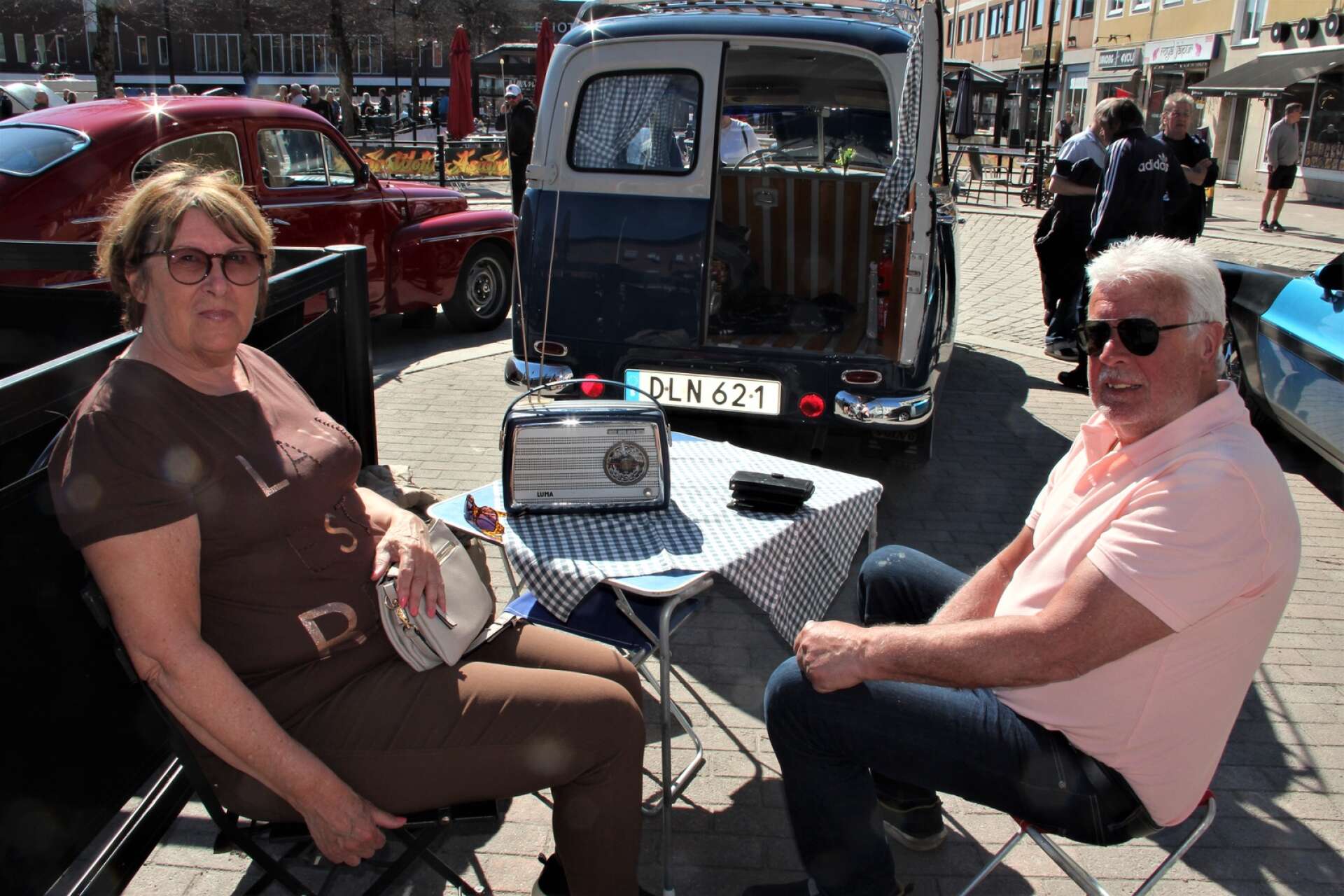 Bengt Sandberg och Inger Olofsson vid sin Volvo Duett. De har tänkt på att allt ska matcha i bästa retrostil, även campingbordet och radion.