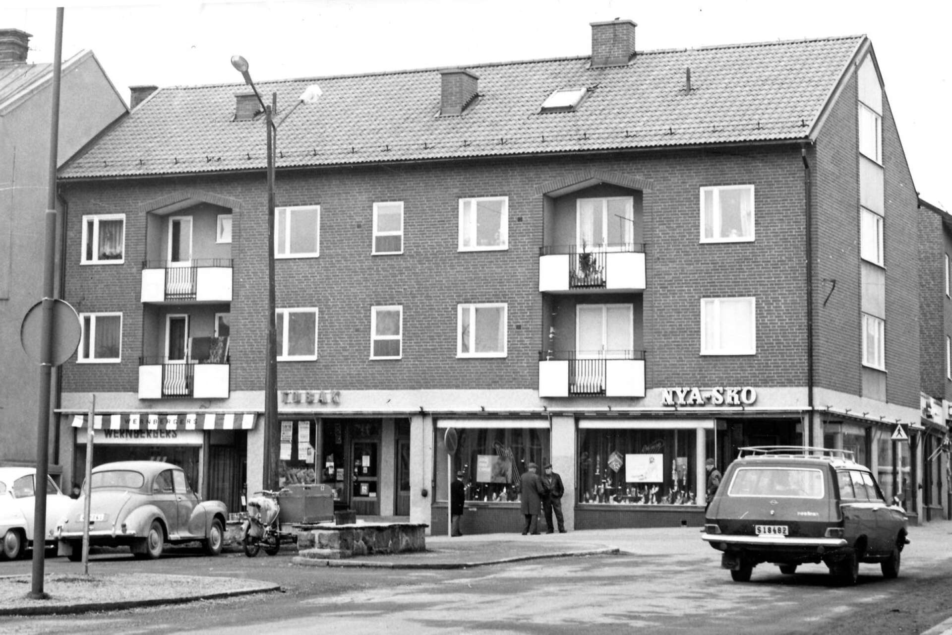 När ett nytt hus i slutet av 1950-talet stod färdigt i hörnet av Östra Storgatan och Perssons gränd flyttade Wernbergers dit och blev granne med Söderströms tobaksaffär och Nya Sko. Bilden är lätt att datera. Den är tagen efter övergången till högertrafik i september 1967 och före vänstra husets rivning precis ett år senare.