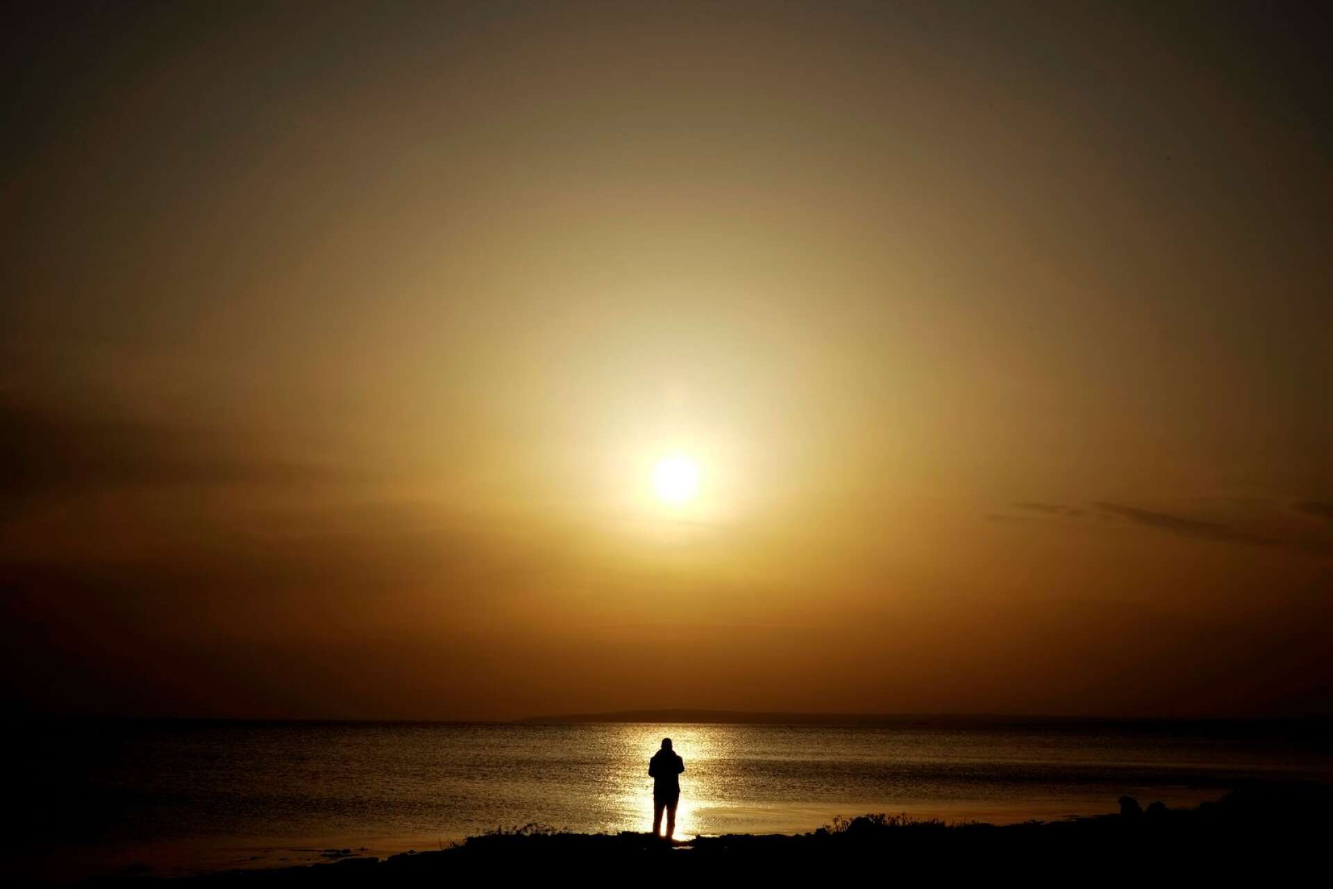 A man stands on the rocks and watches the sea and the sunset in Ayia Napa, Cyprus, Monday, Feb. 27, 2017. (AP Photo/Petros Karadjias) 