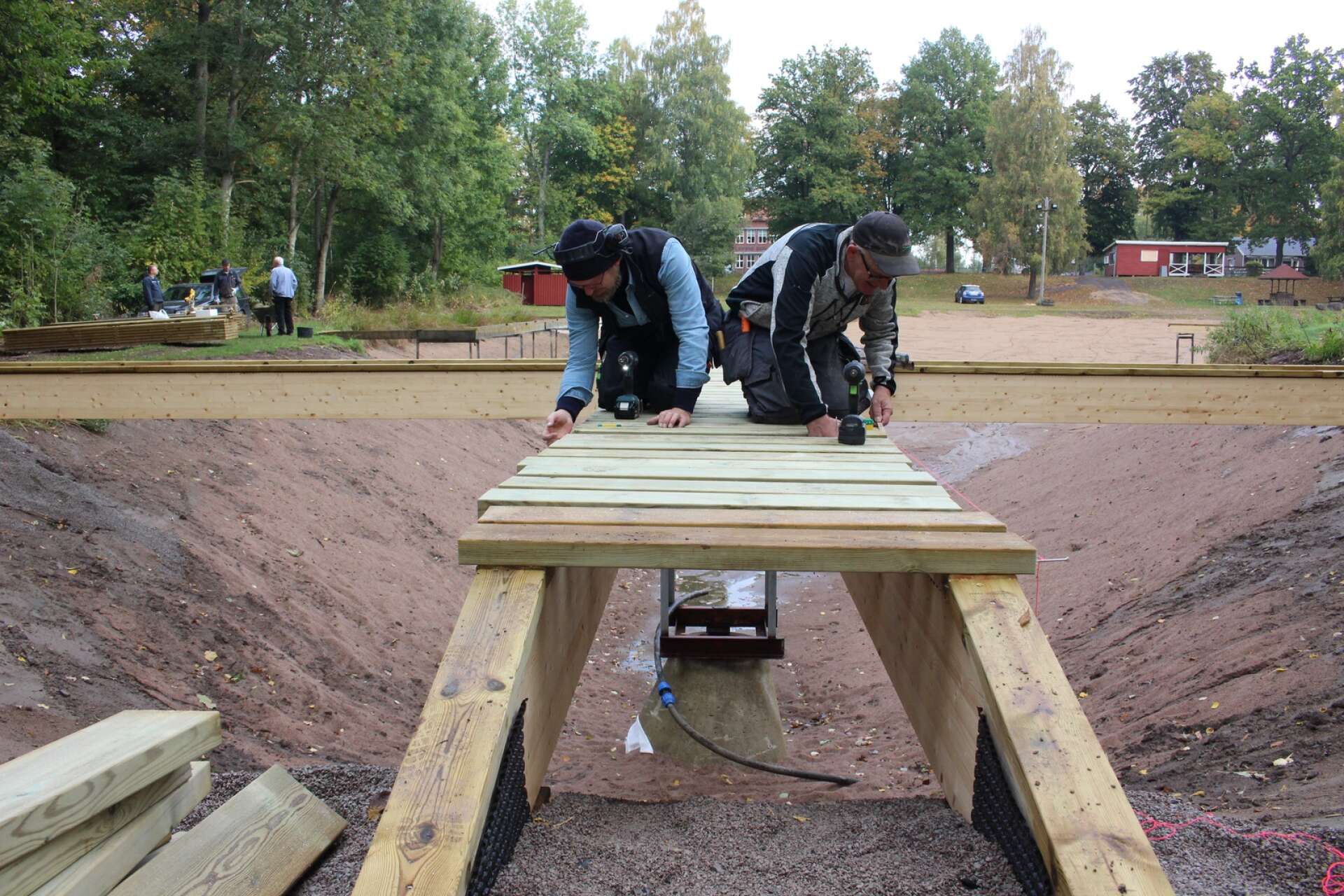 Johan Svantesson och Bengt-Ove Jonsson i full färd med att skruva tvärbrädor på den nya bryggan.