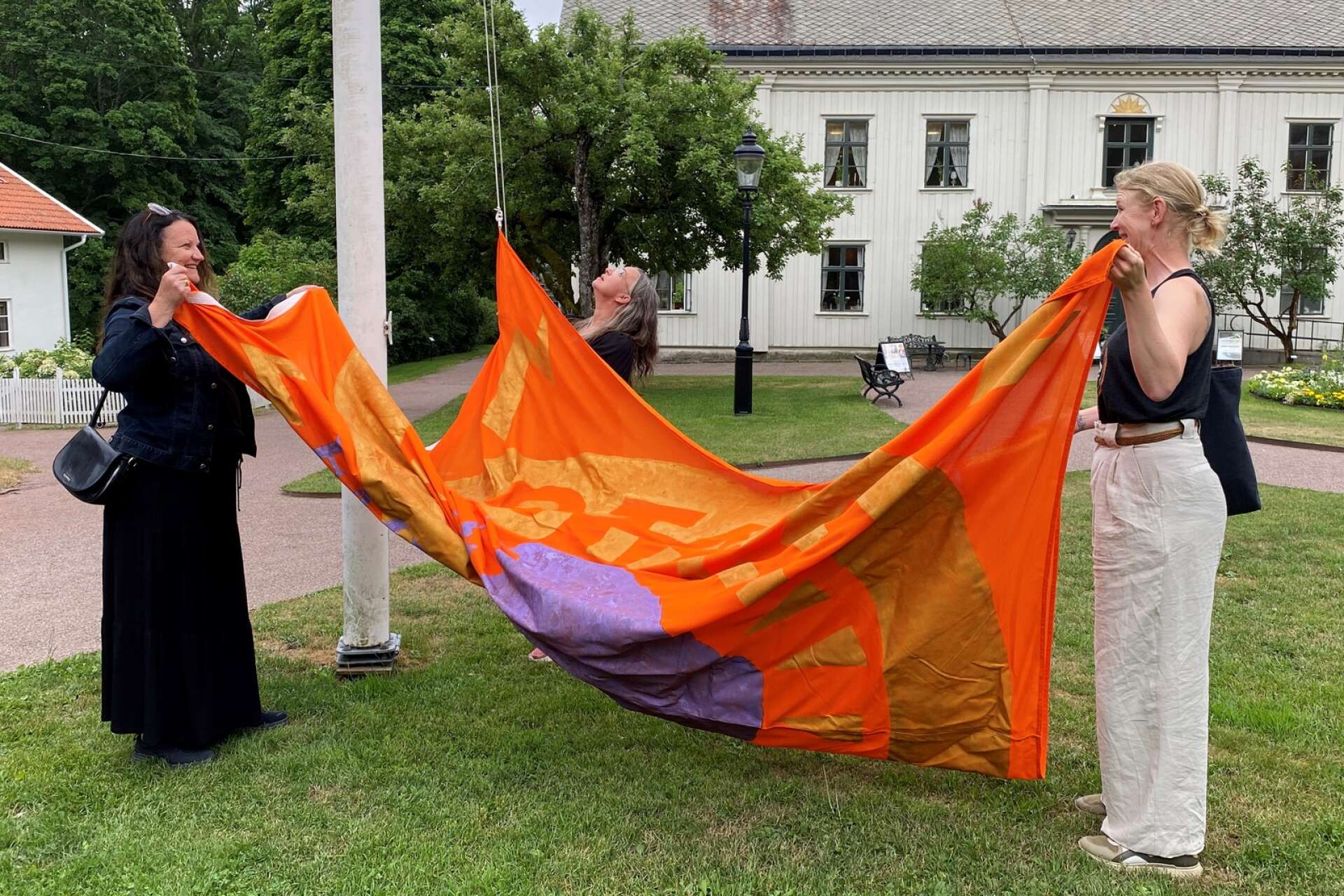 En flagga som representerar Gustaf Frödings mor Emilia hissades på tisdagen upp på Alsters herrgård. Anna Ehnsiö, Helene Karlsson och Sara Falkstad i konstgruppen Otalt har skapat verket, som ingår i sommarutställningen ”I skogen”. 