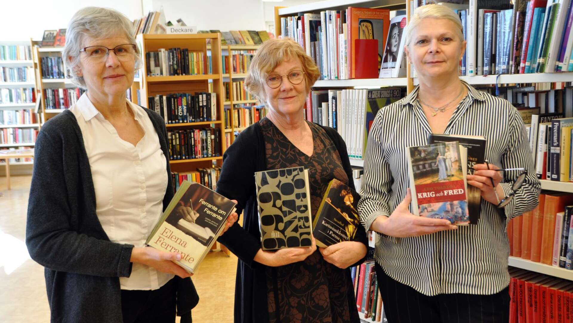 Boklånaren Anneli Saibi, bibliotekarien Kerstin Vogel och boklånaren Nina Aleksic med ett urval av klassisk litteratur, lämplig att läsa under en karantän. 