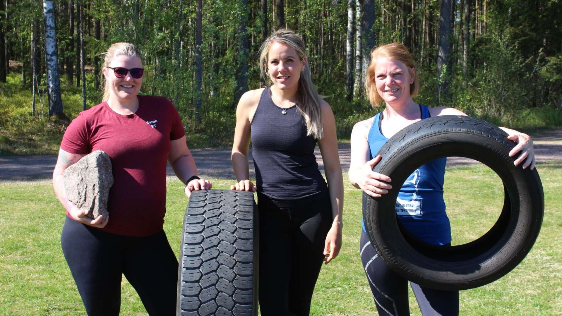 Sarah Mossfeldt Häll, Lina Lönnström och Caroline Alm visar övningar i Björkvallens utegym, med däck och stenar och med egen kroppsvikt. 