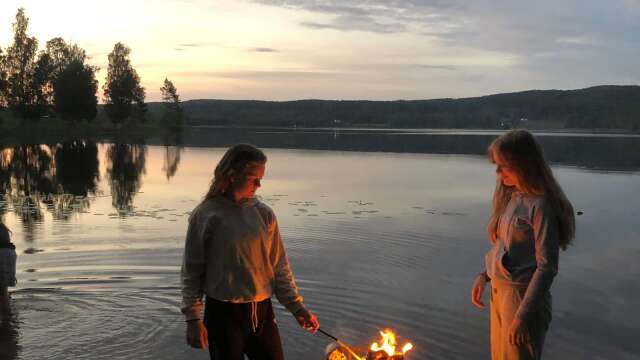 Kusinerna Tyra Andersson och Mollie Terning grillar en tidig sommarmorgon efter en natt i tält vid Bysjön.