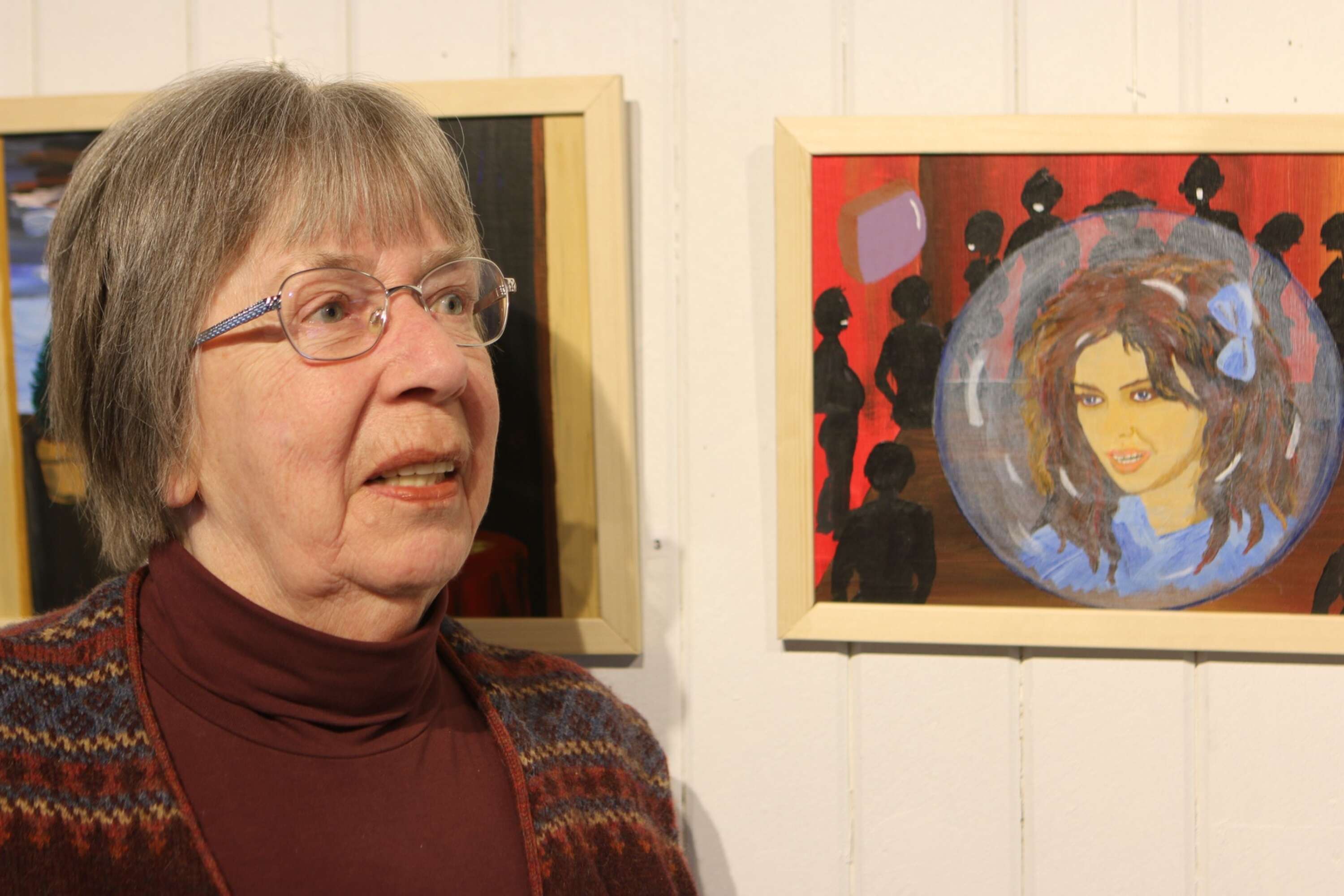 Här står Karin Stridh bredvid en av hennes första tavlor, kallad för Utanförskap.