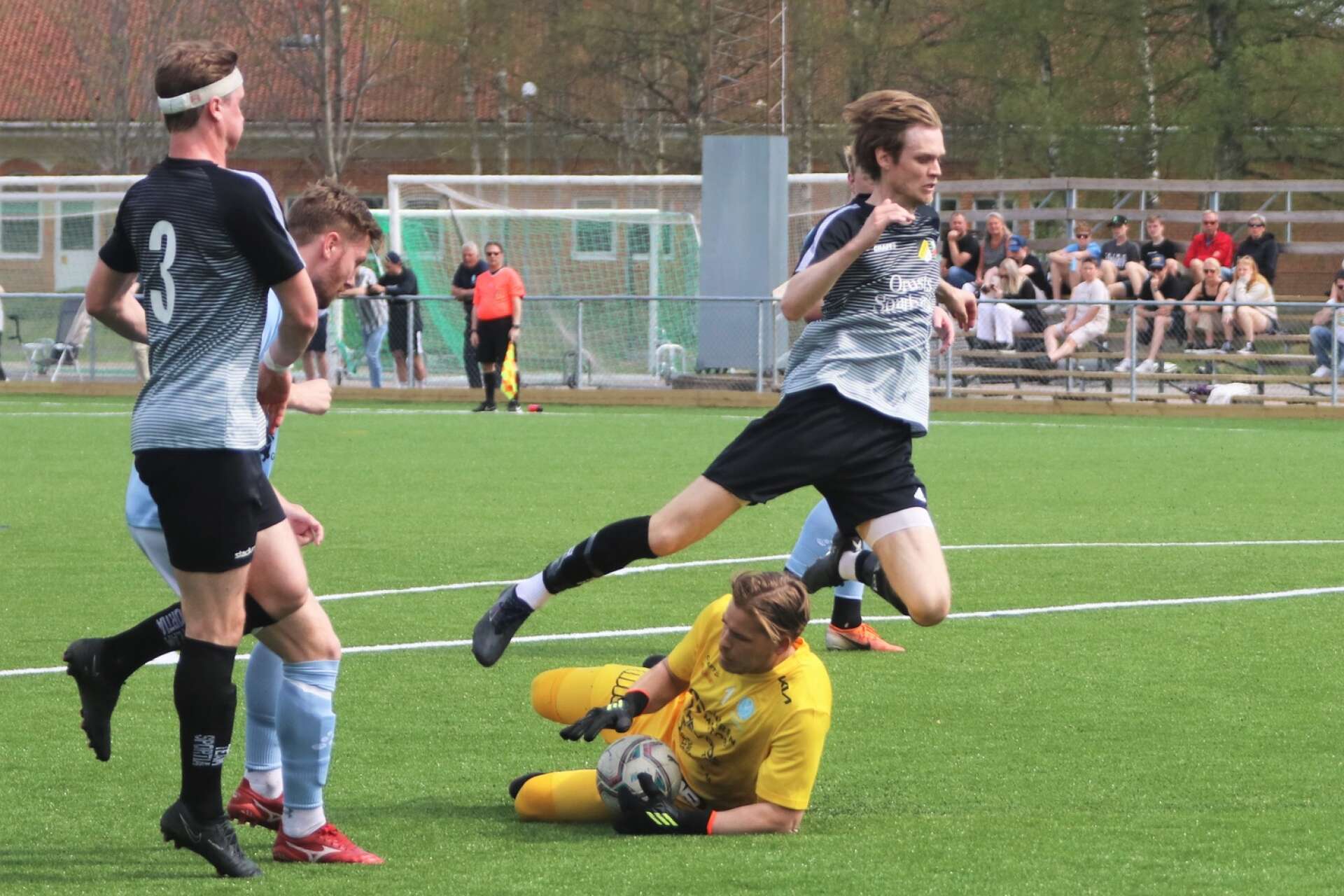 Vikens målvakt Christoffer Härd räddar bollen framför fötterna på Henån/Gillbys John Olsson och en hoppande Alexander Hellohf medan lagkamraten Jacob Ljung täcker.