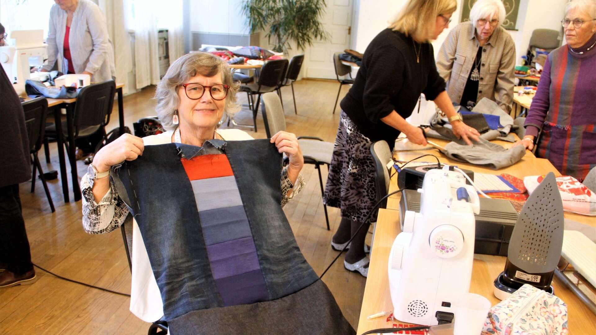 Bibbi Linder med sitt återbruksprojekt. Klänningen tillverkade hon av en gammal kjol, byxben av jeans och några tygprover i olika färgtoner.