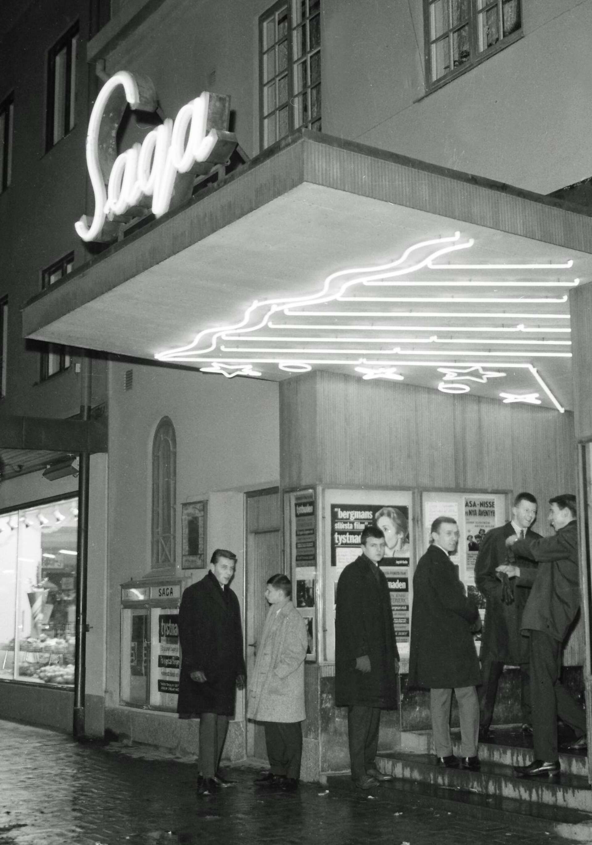 Sagas entré har skiftat utseende några gånger. Med neonljus lockade man en gång besökare till bion. Bilden togs 1963. Affischerna avslöjar att filmen som då visades var Ingmar Bergmans Tystnaden. Som matiné gick Åsa-Nisse på nya äventyr.