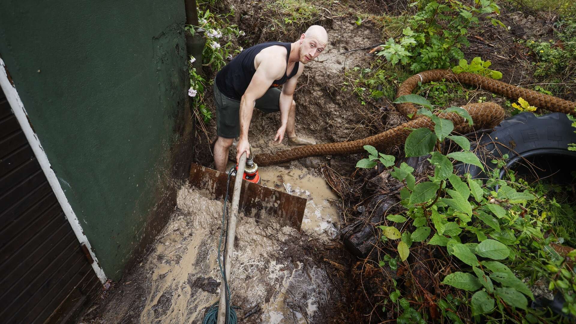 Jimmie Wiklund fick översvämning i sin källare i Säffle och kämpar med att pumpa ut vattenmassorna från trädgården så det inte tar sig in till källaren igen.