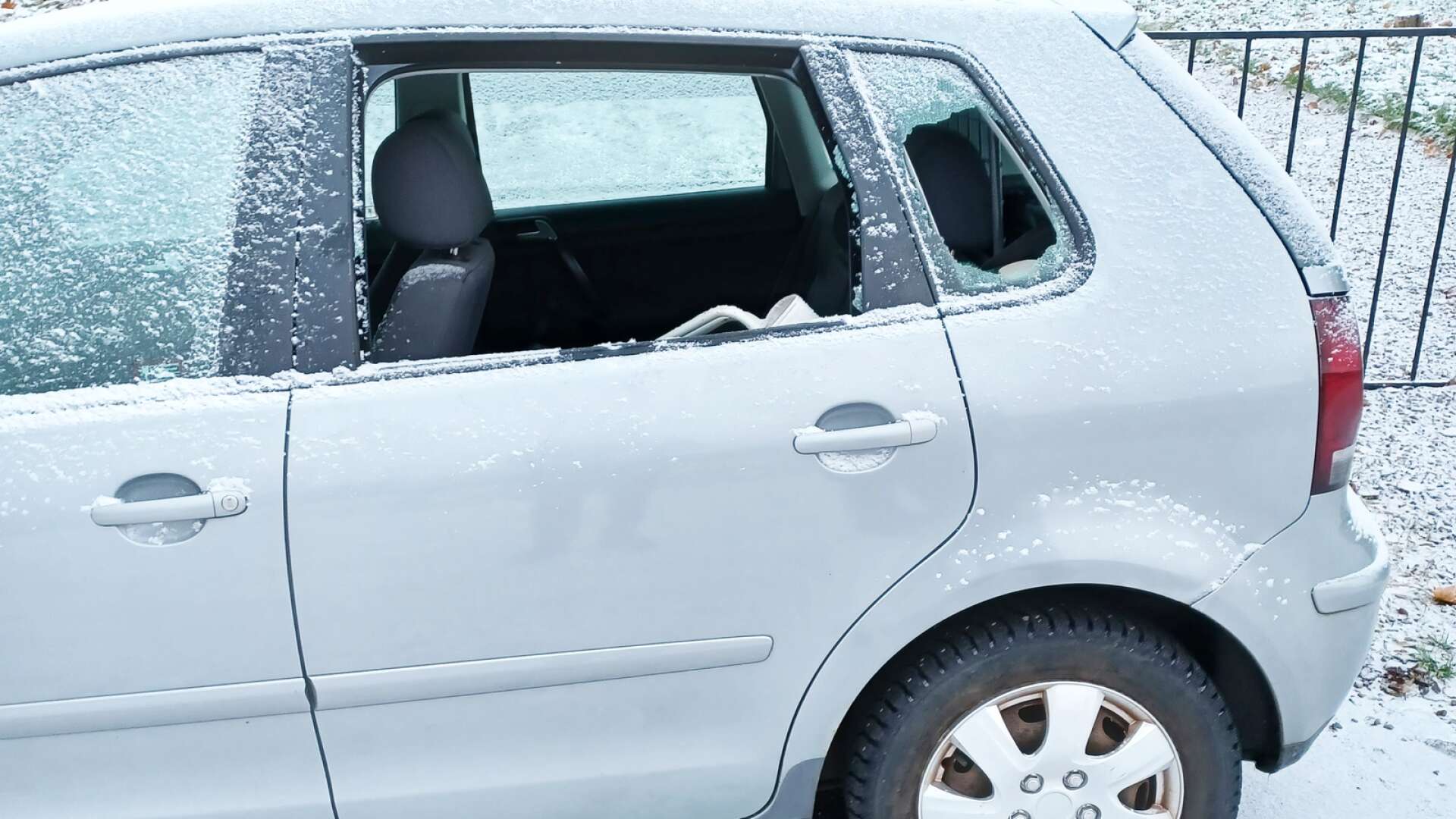 Personbilen med krossade fönsterrutor.