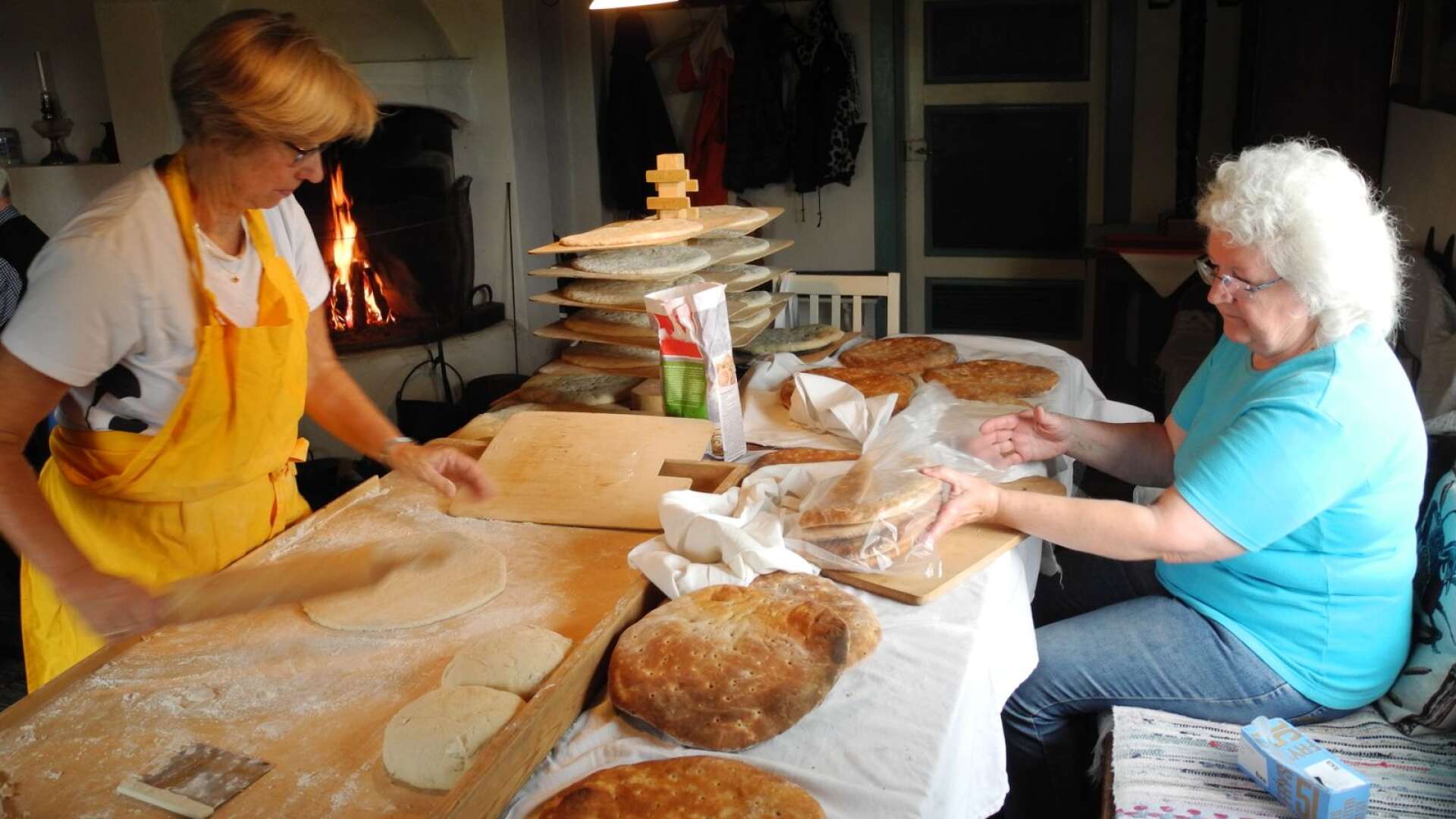 Birgitta Härd bakar och Gunilla Henriksson packar brödet till försäljning. Ungefär 70 personer besökte bakdagen i Ånimskogs hembygdsgård.