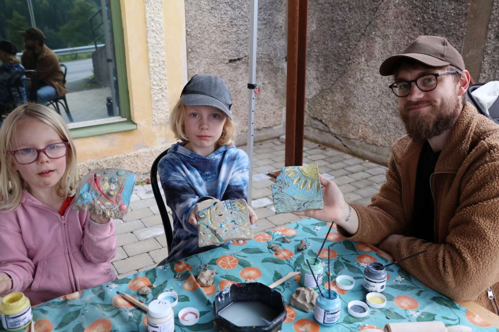 Byafest i Dals Långed. Här är det Lykke Amnehagen, Vide Amnehagen och pappa Anton Amnehagen som skapat konstverk i lerplattor.